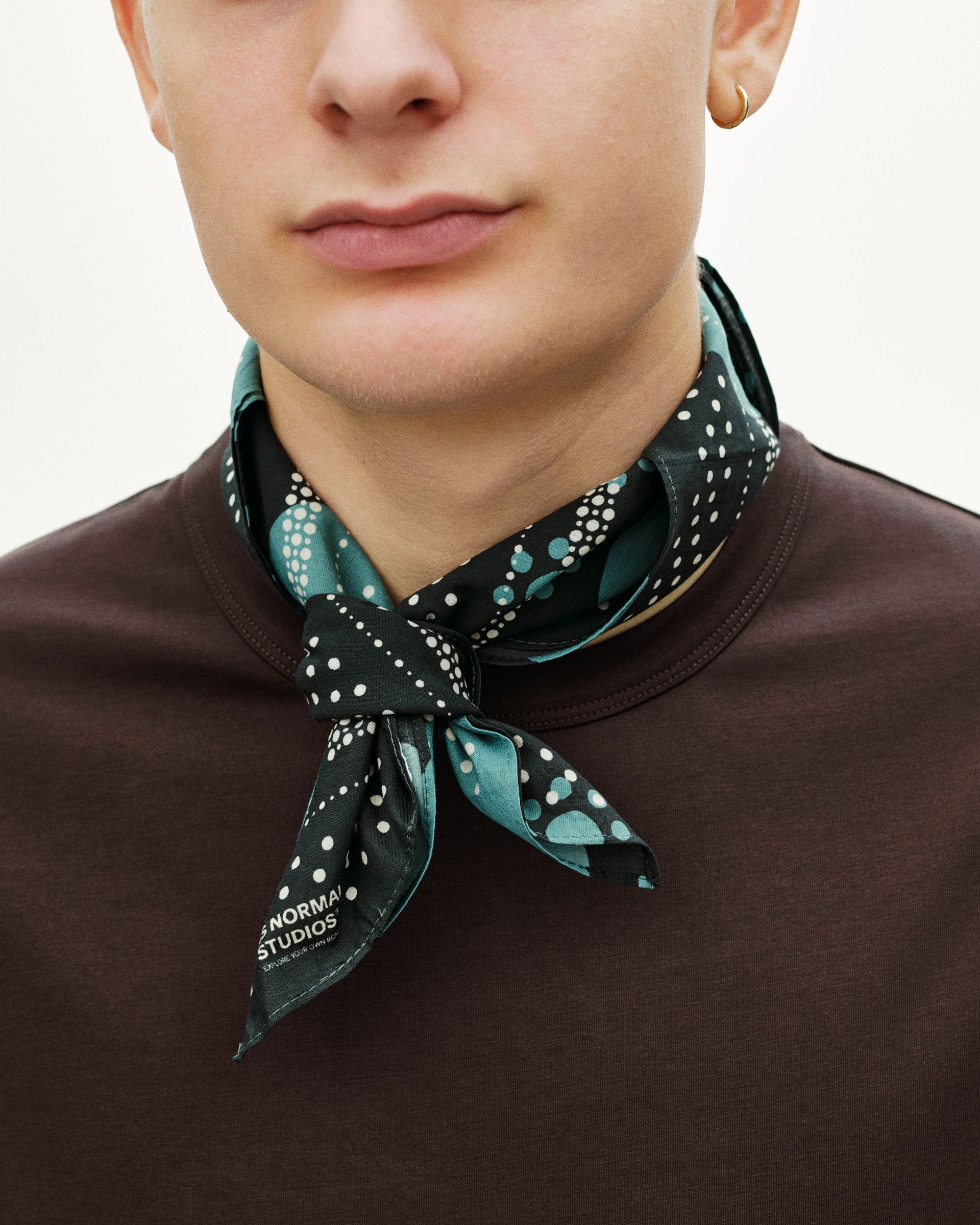 Navy Off-Race bandana on model, tied around neck with white polka dot pattern
