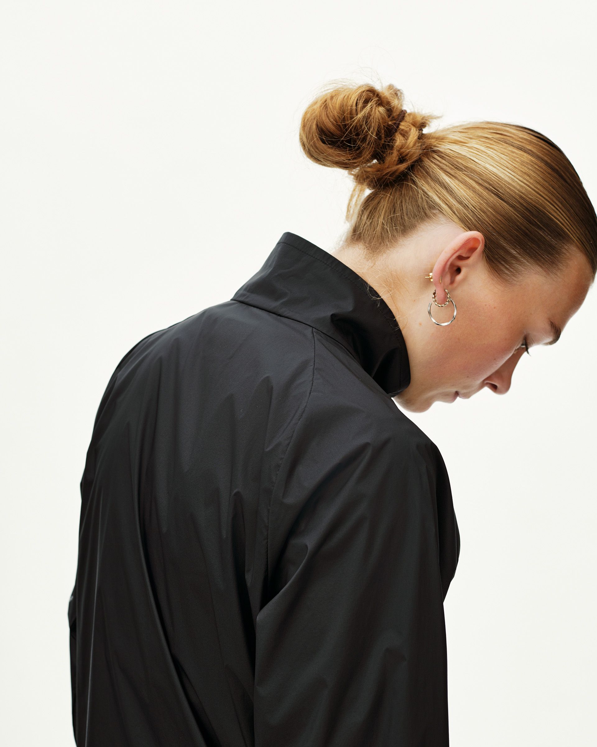 Black Balance Windproof jacket on model, rear view with high collar