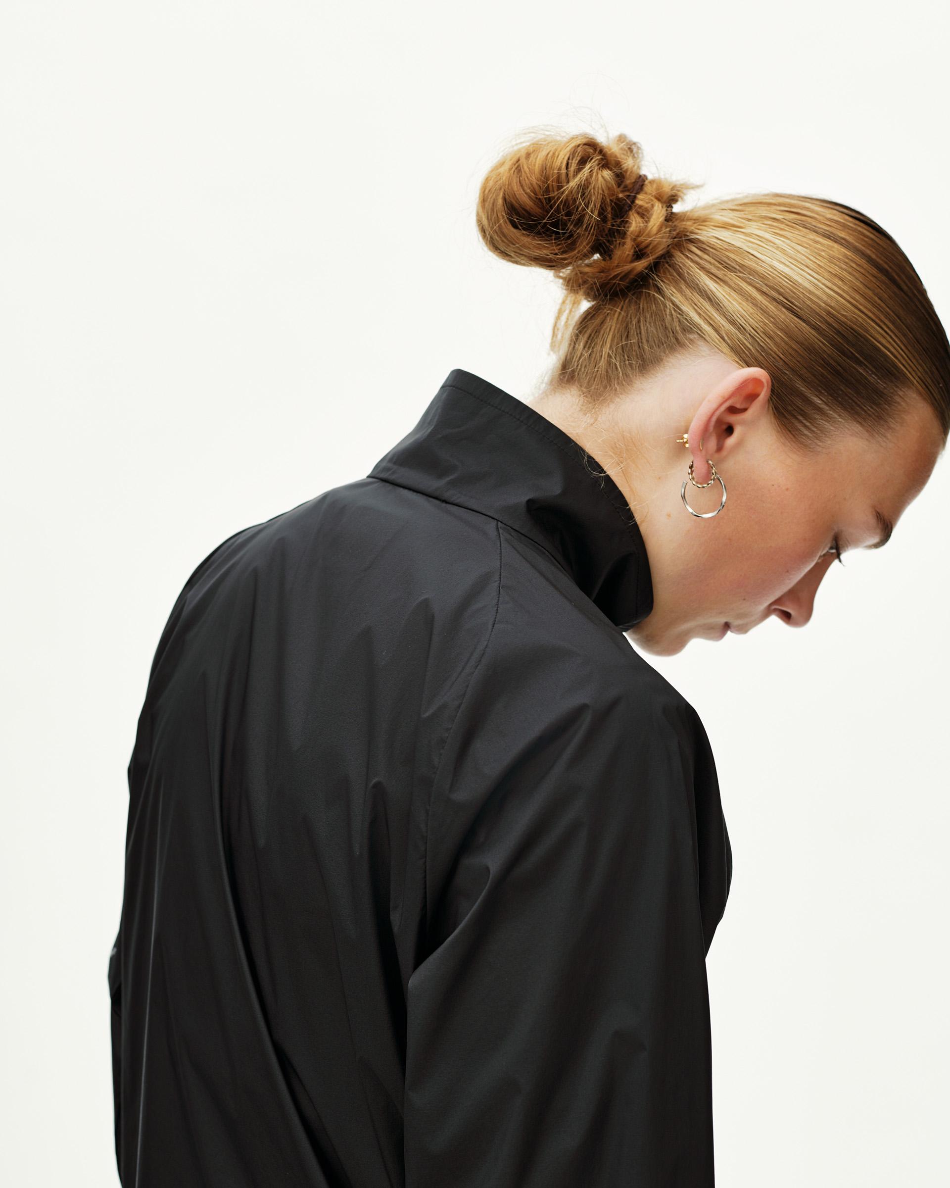 Black Balance Windproof jacket on model, rear view with high collar