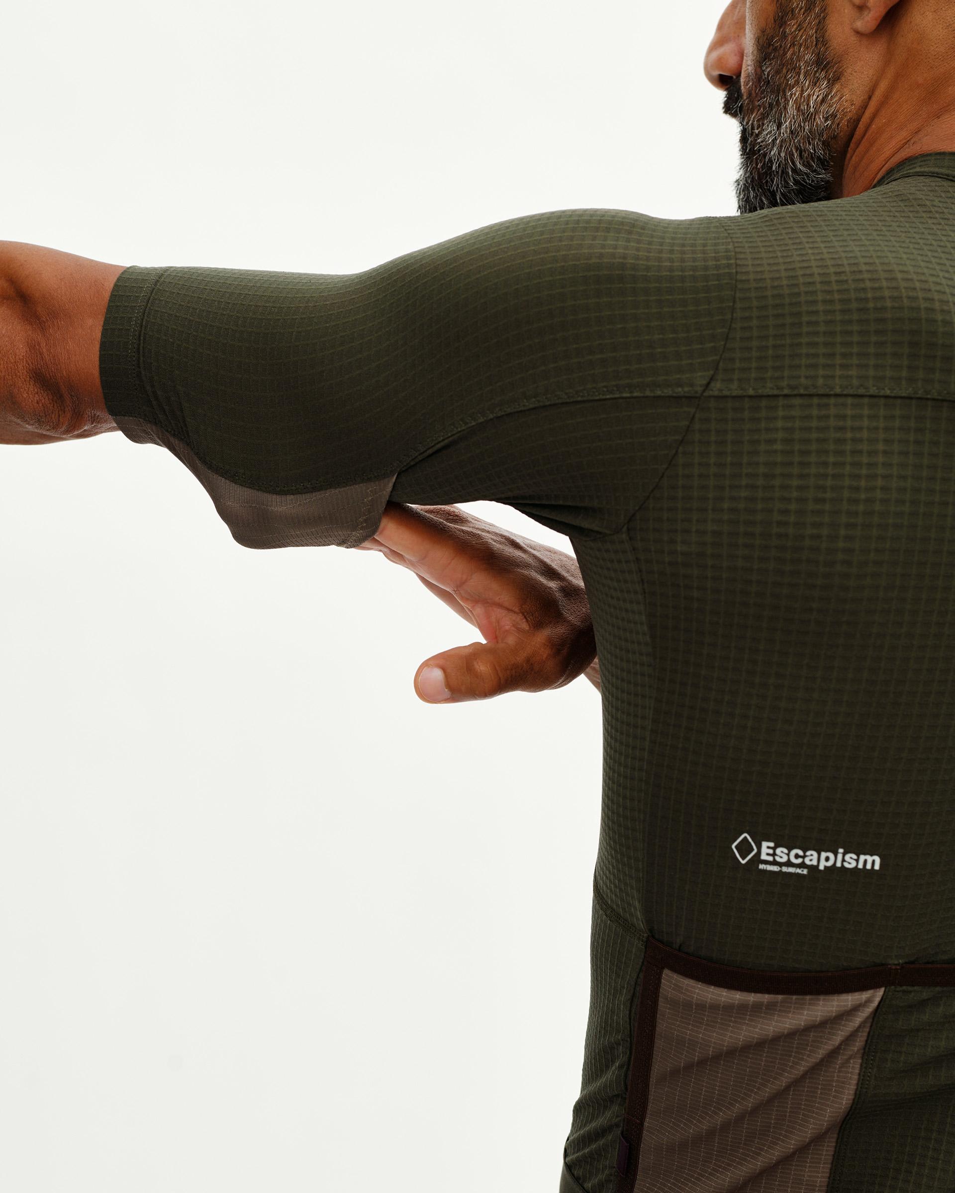 Dark Olive Escapism cycling jersey on model, rear detail view with grid texture and contrast dark underarm panel
