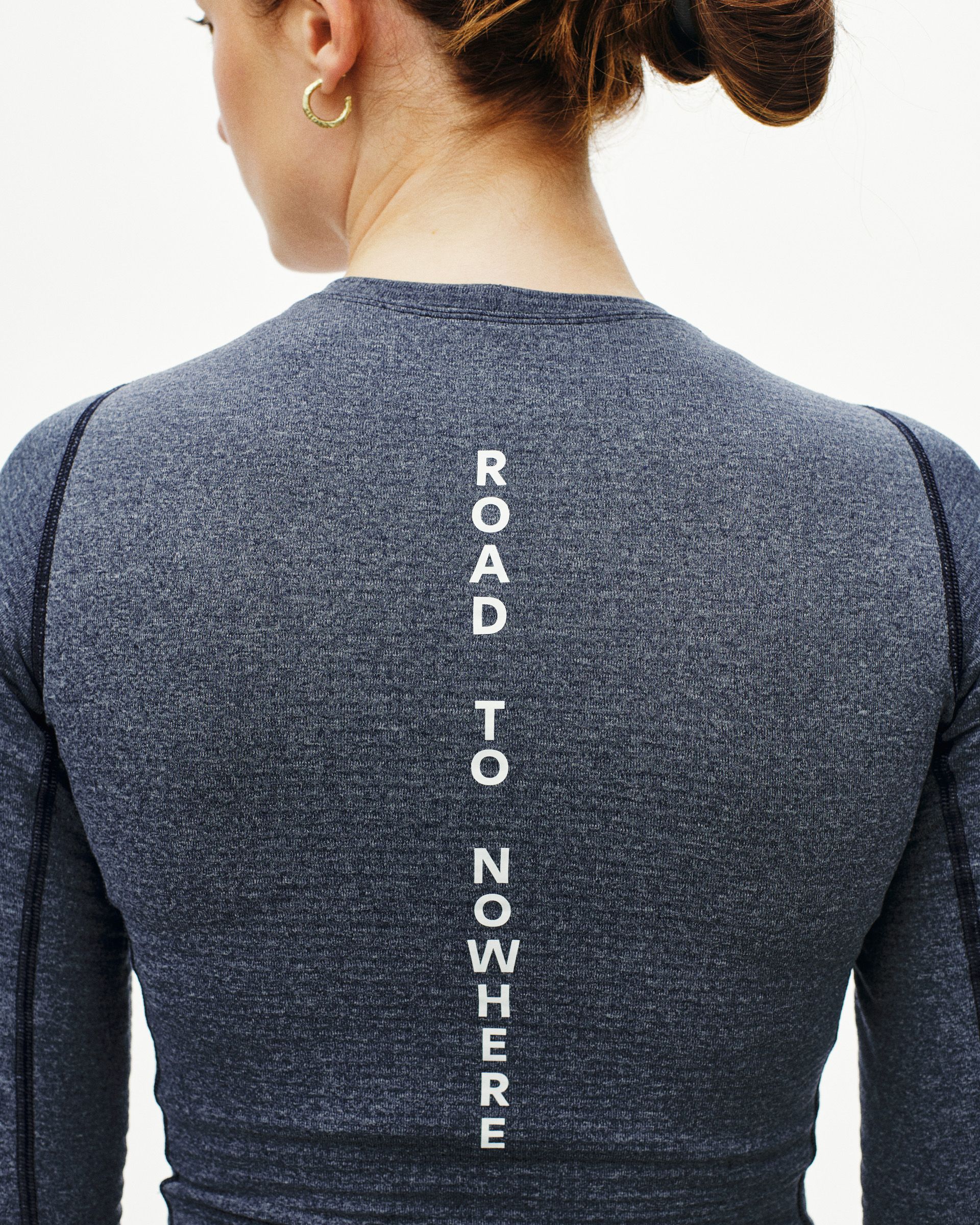 Navy thermal long sleeve base layer on model, rear view with white vertical spine text