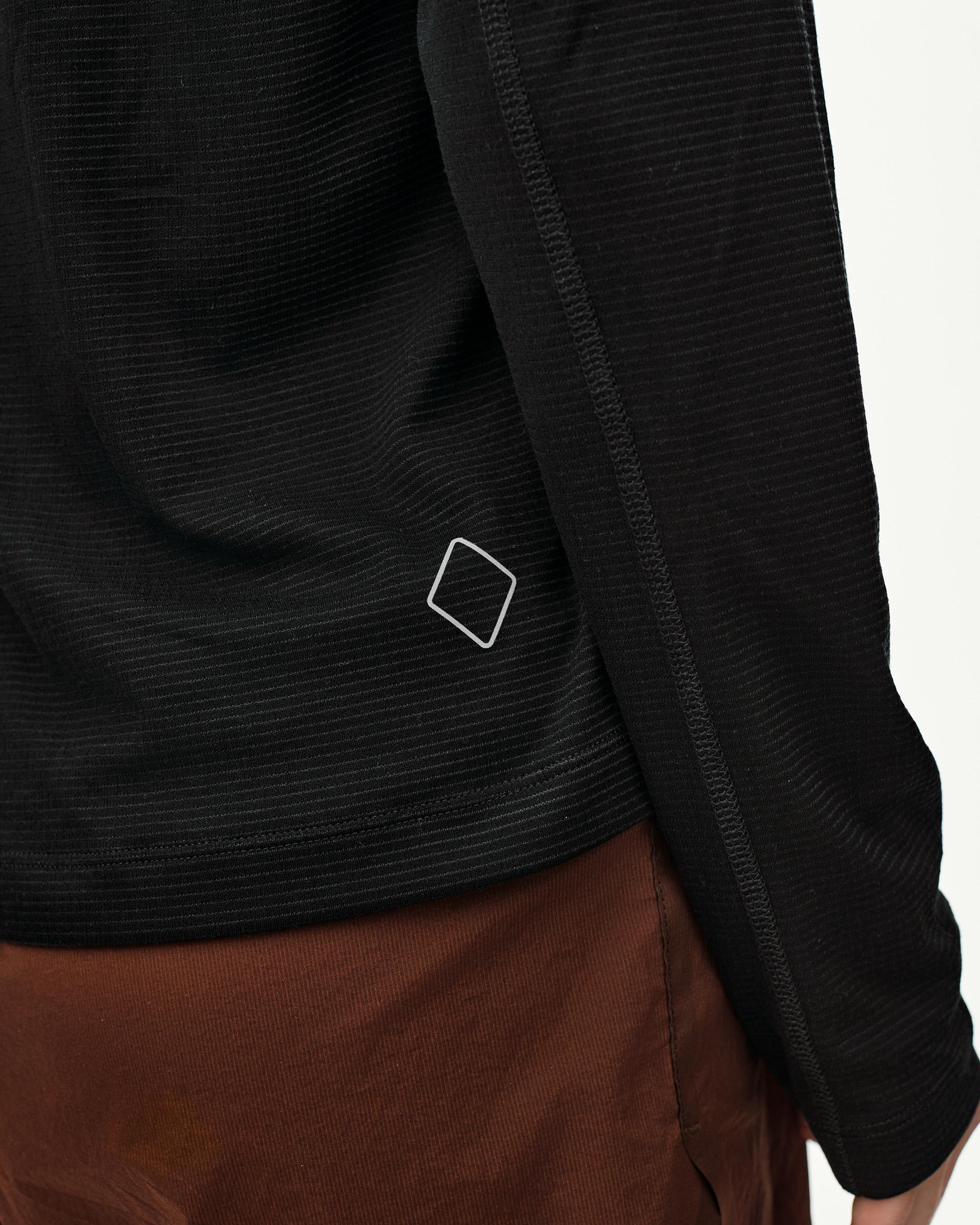 Black Balance long sleeve T-shirt, side detail on model showing ribbed texture and diamond logo at hem