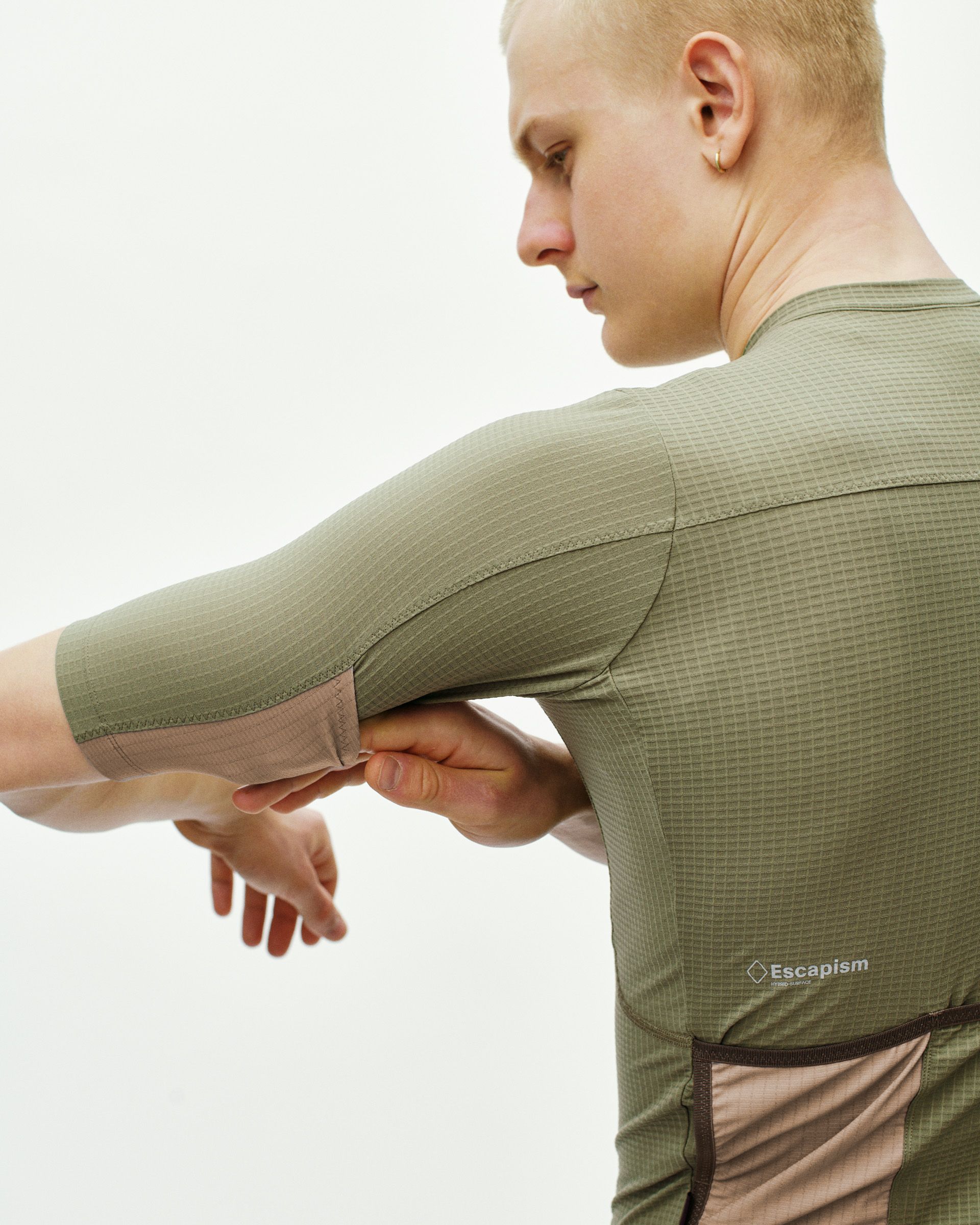 Light Olive Escapism cycling jersey on model, side view with textured fabric and contrast hem