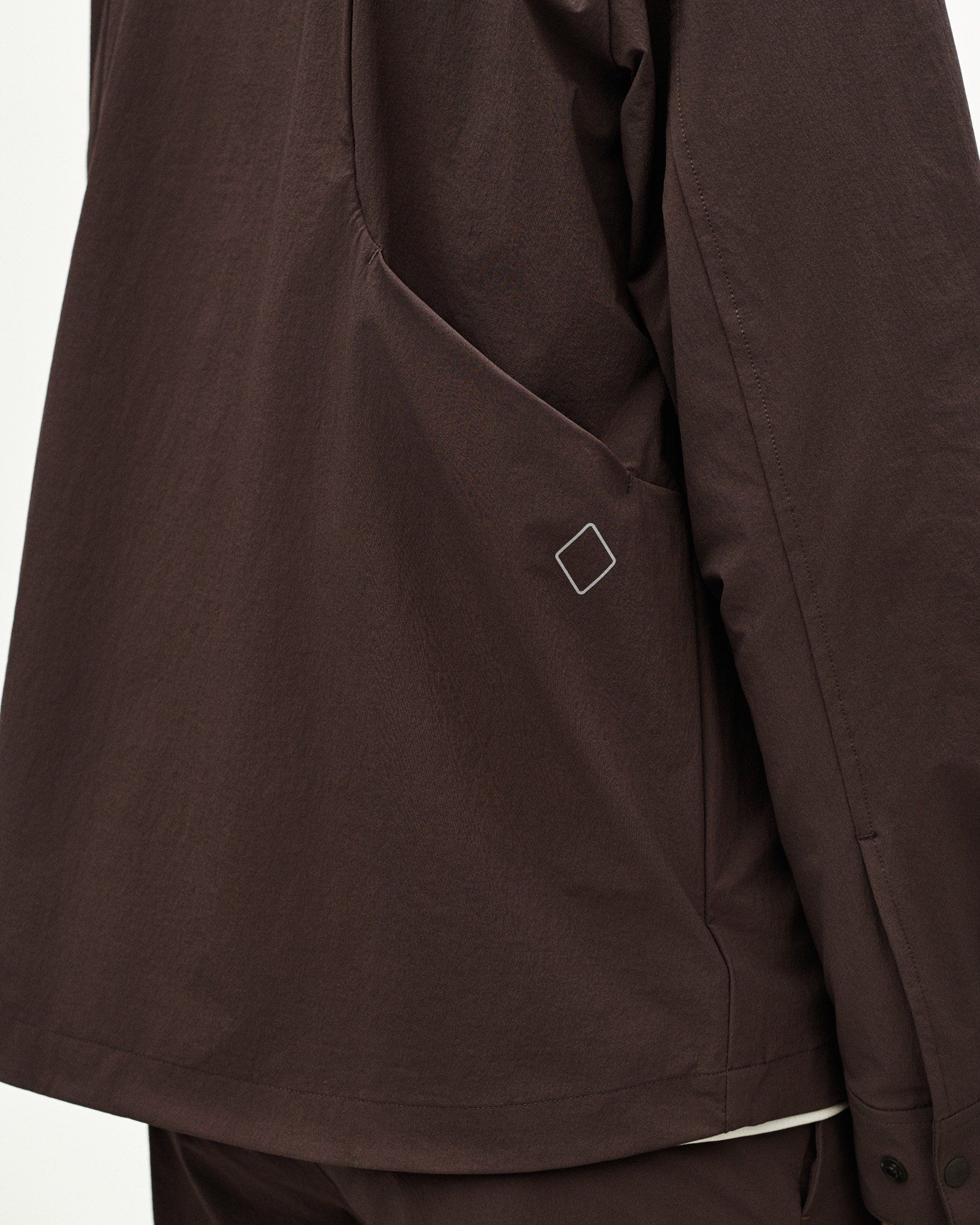 Dark Purple Off-Race Tech Overshirt, detail view showing white diamond logo and side seam construction