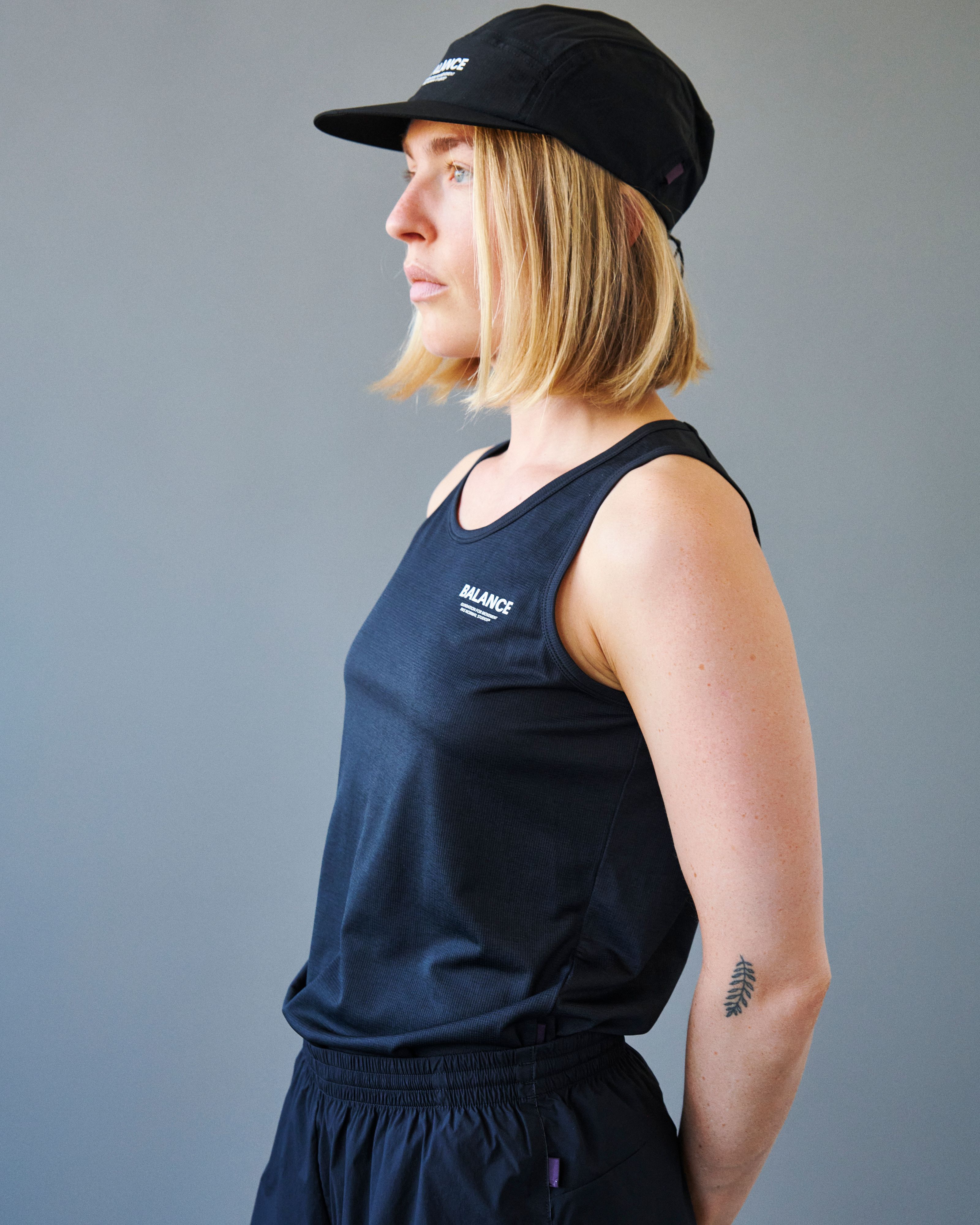 Black Balance singlet on model in side view with white chest logo