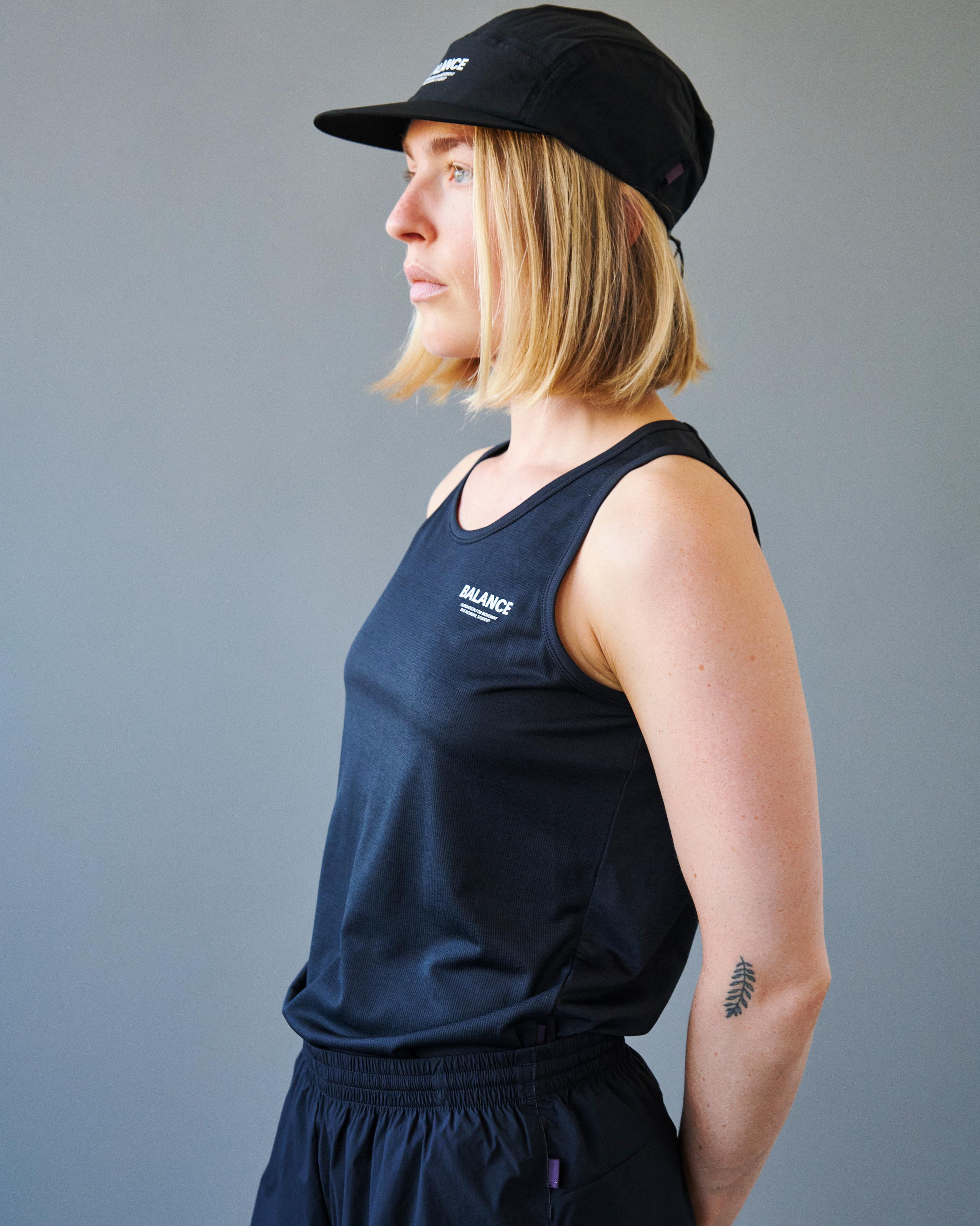 Black Balance singlet on model in side view with white chest logo