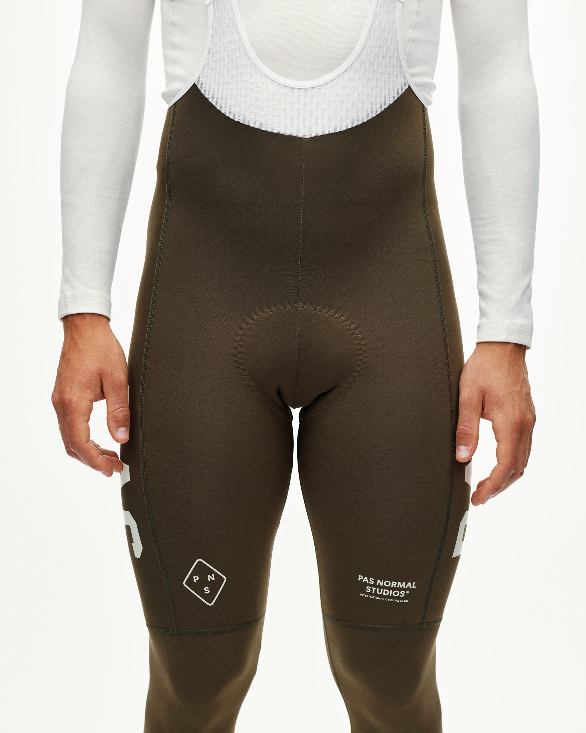 Dark Earth khaki PAS Mechanism Thermal Long cycling bibs on model, front view with white leg print