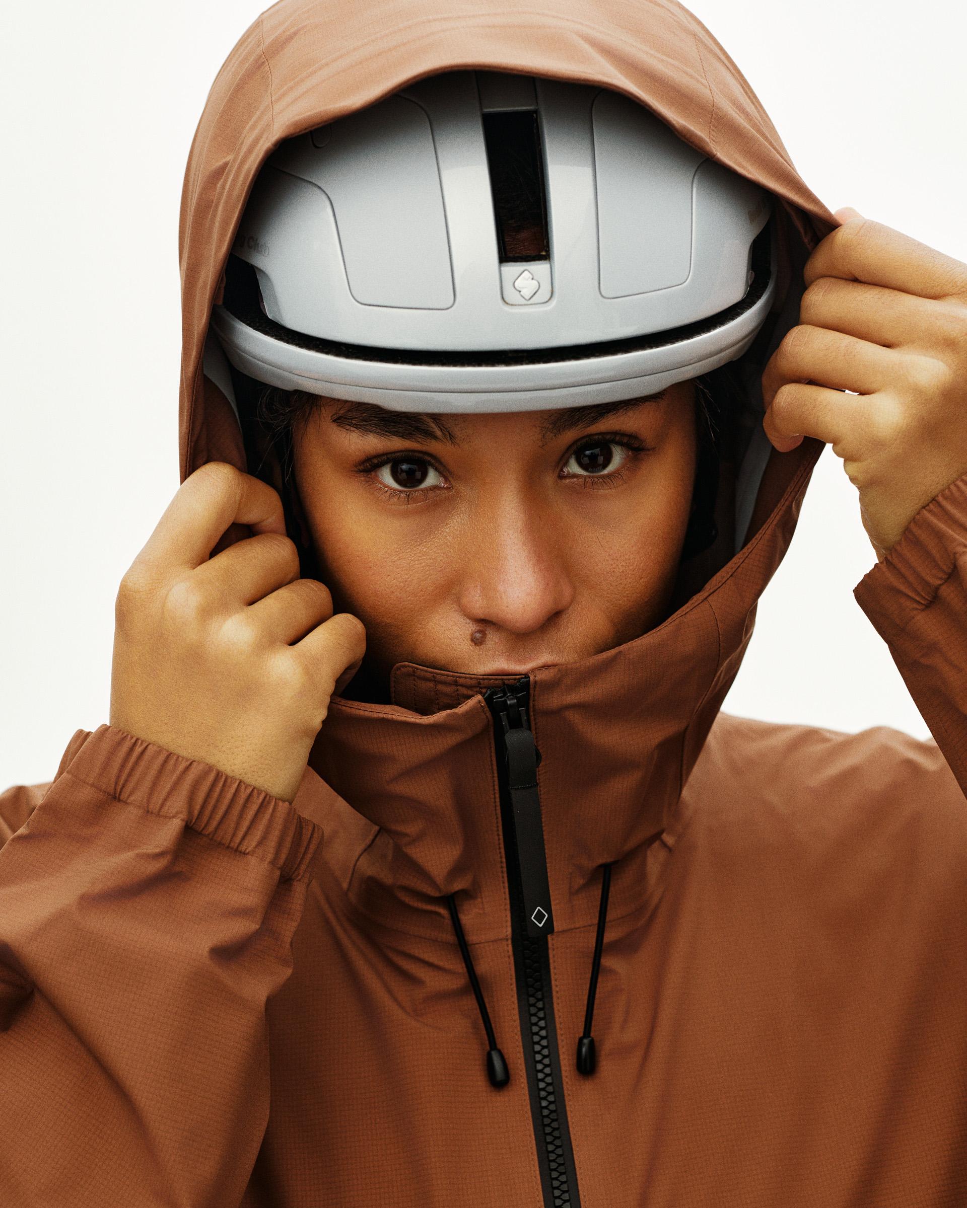 Brown Off-Race 3L Poncho on model with helmet and drawstring hood