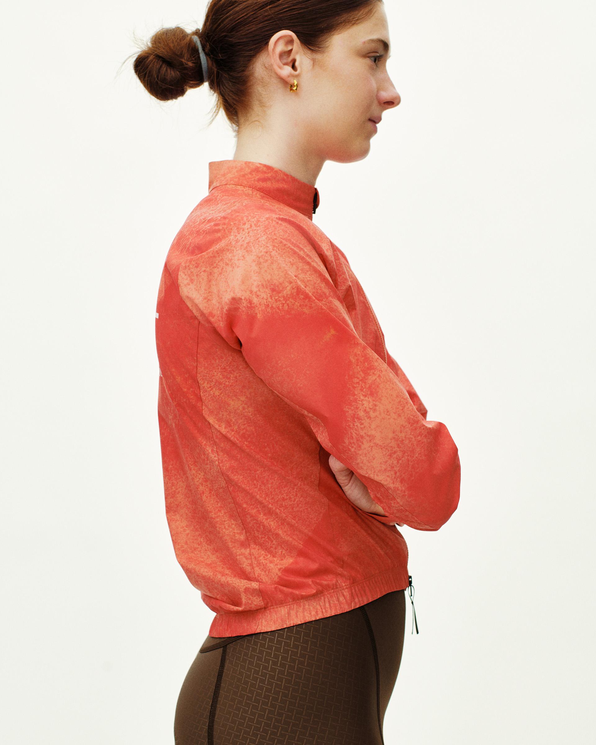 Orange Mechanism Stow Away jacket on model, side view with textured print