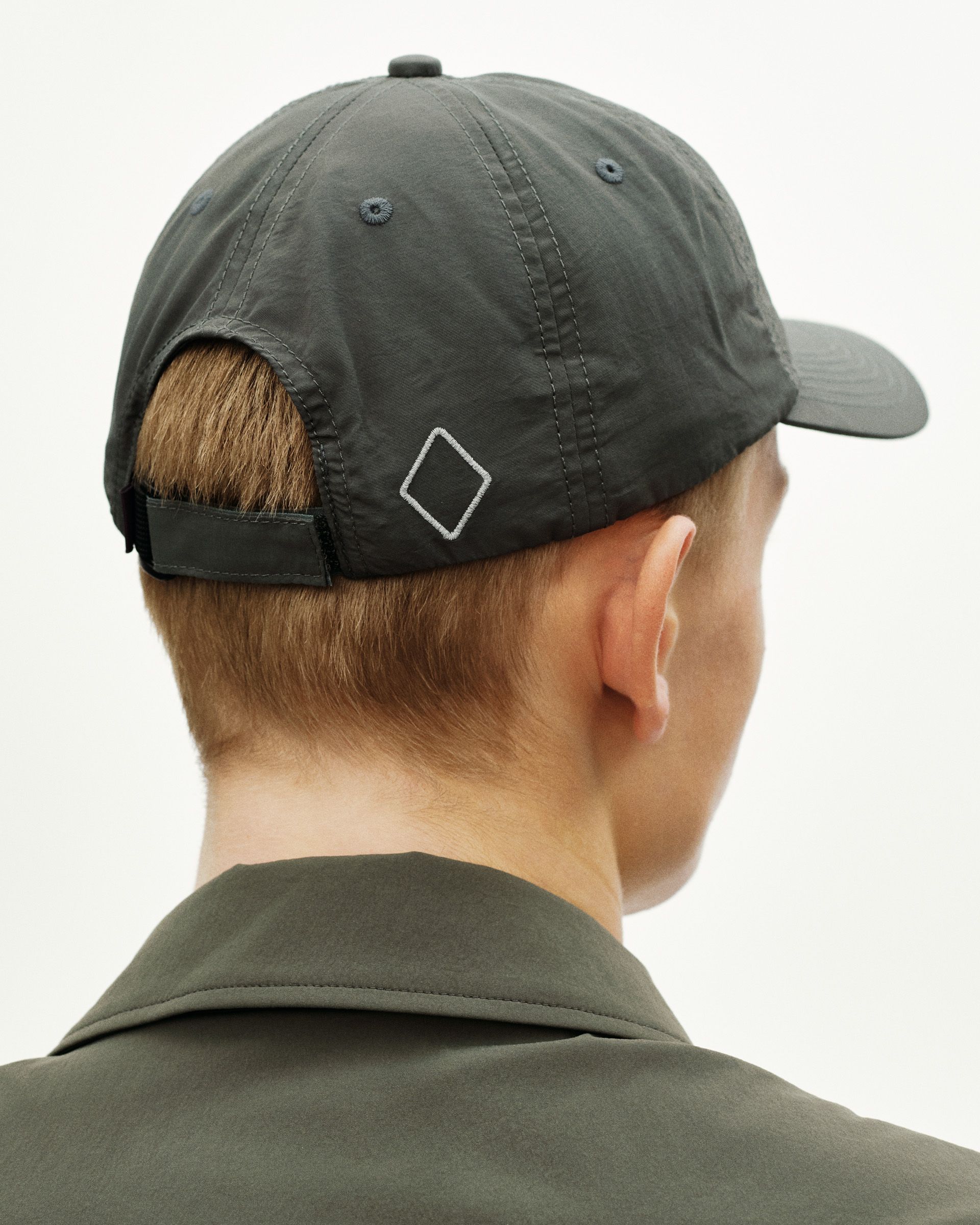 Dark Grey Off-Race cap, rear view on model with white diamond logo and adjustable strap