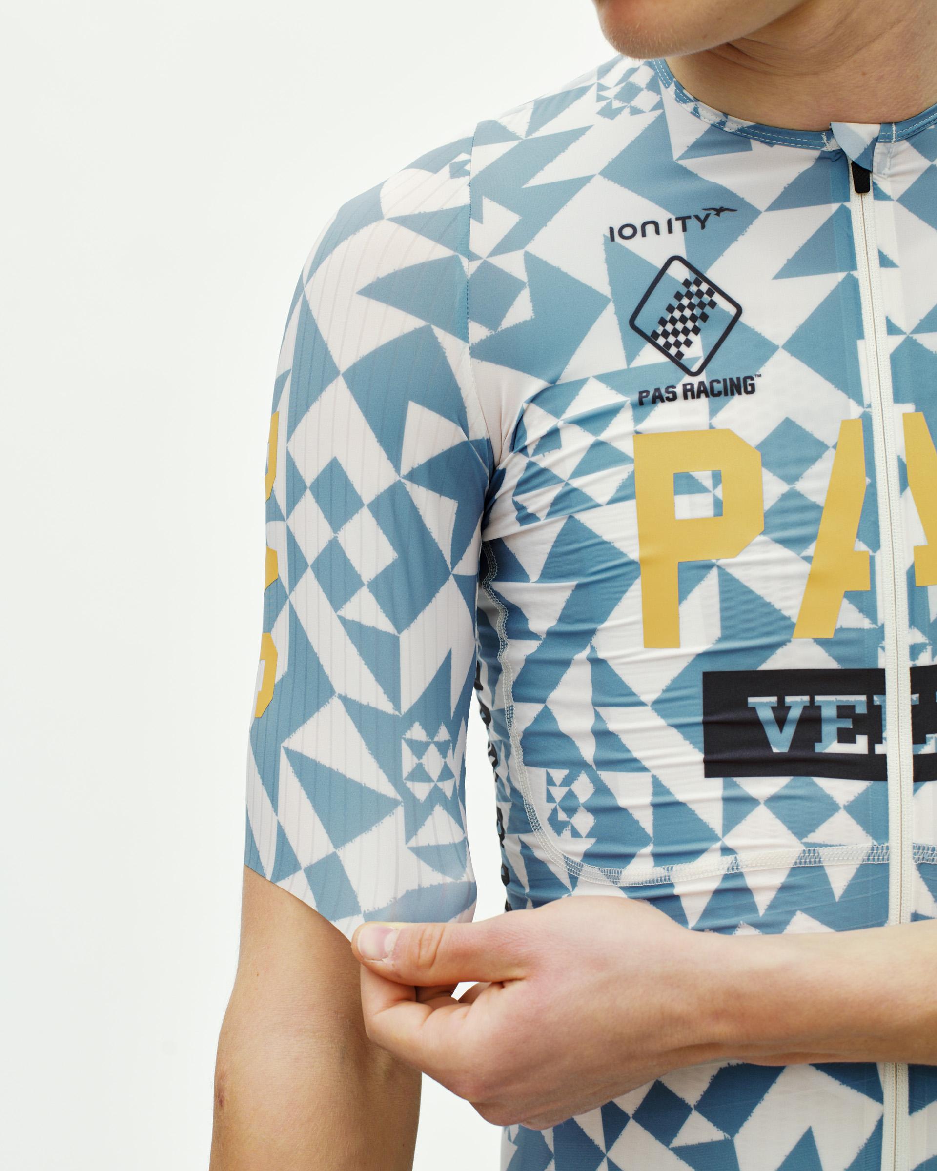 Origami Light Blue PAS Mechanism Pro cycling jersey on model, side detail with geometric print and gold chest lettering