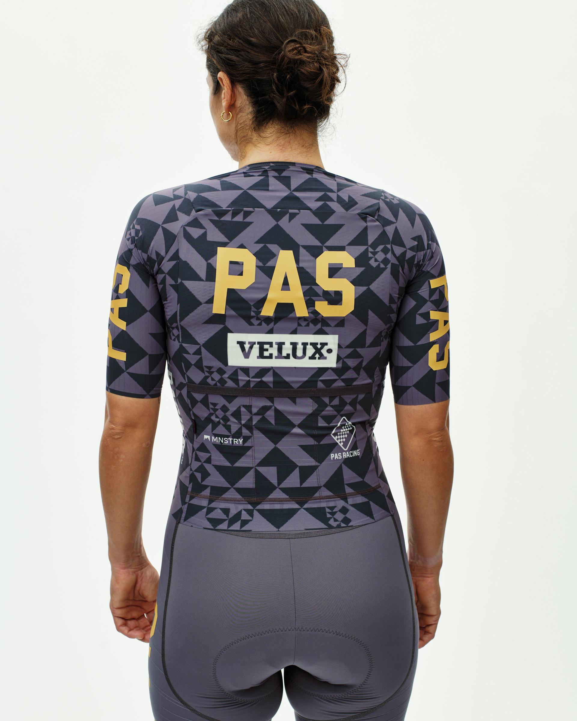 Origami Grey Mechanism Pro women's cycling jersey on model, rear view with geometric triangle print and gold Racing text