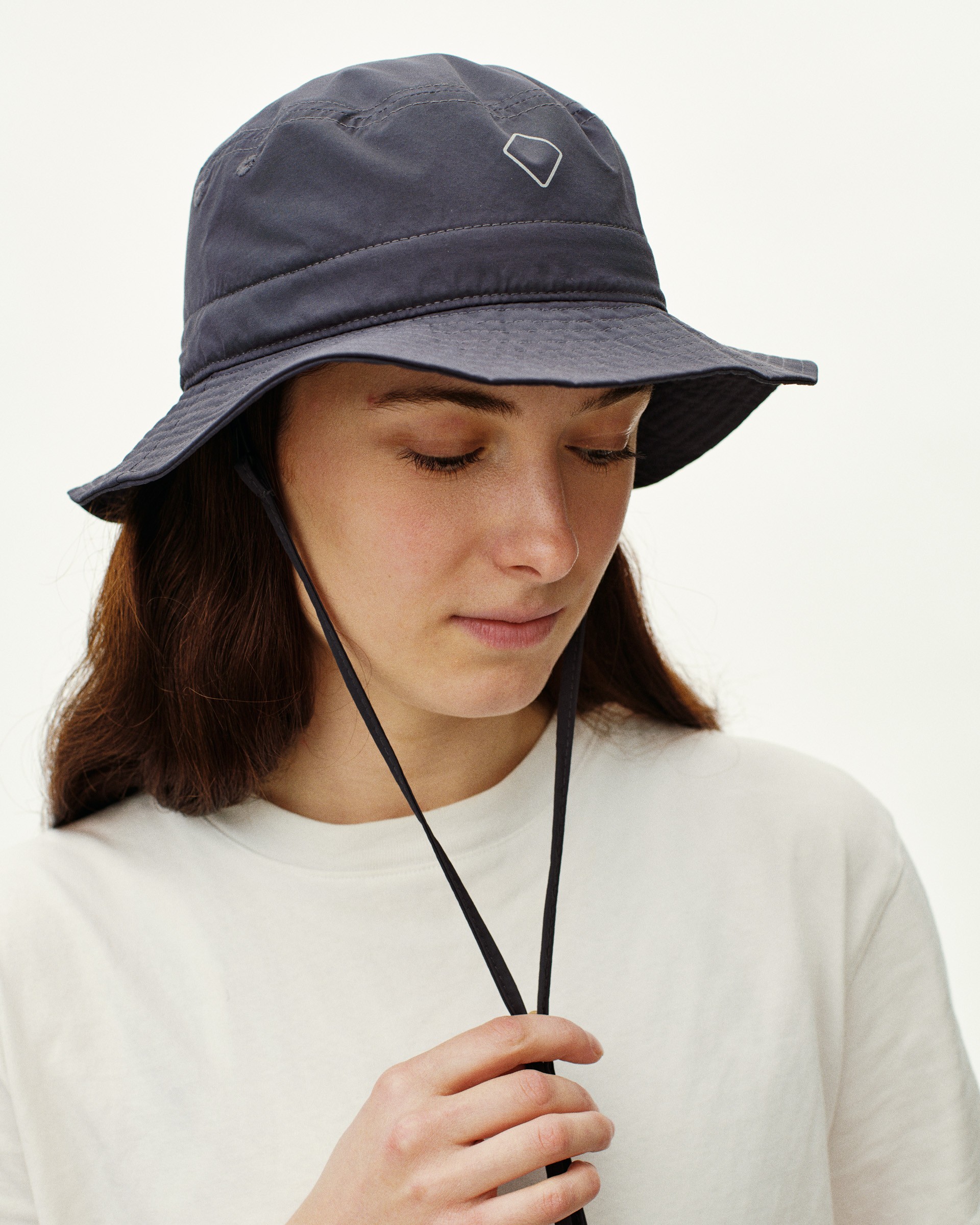 Dark gray bucket hat with adjustable cord and removable neck strap for secure fit during cycling