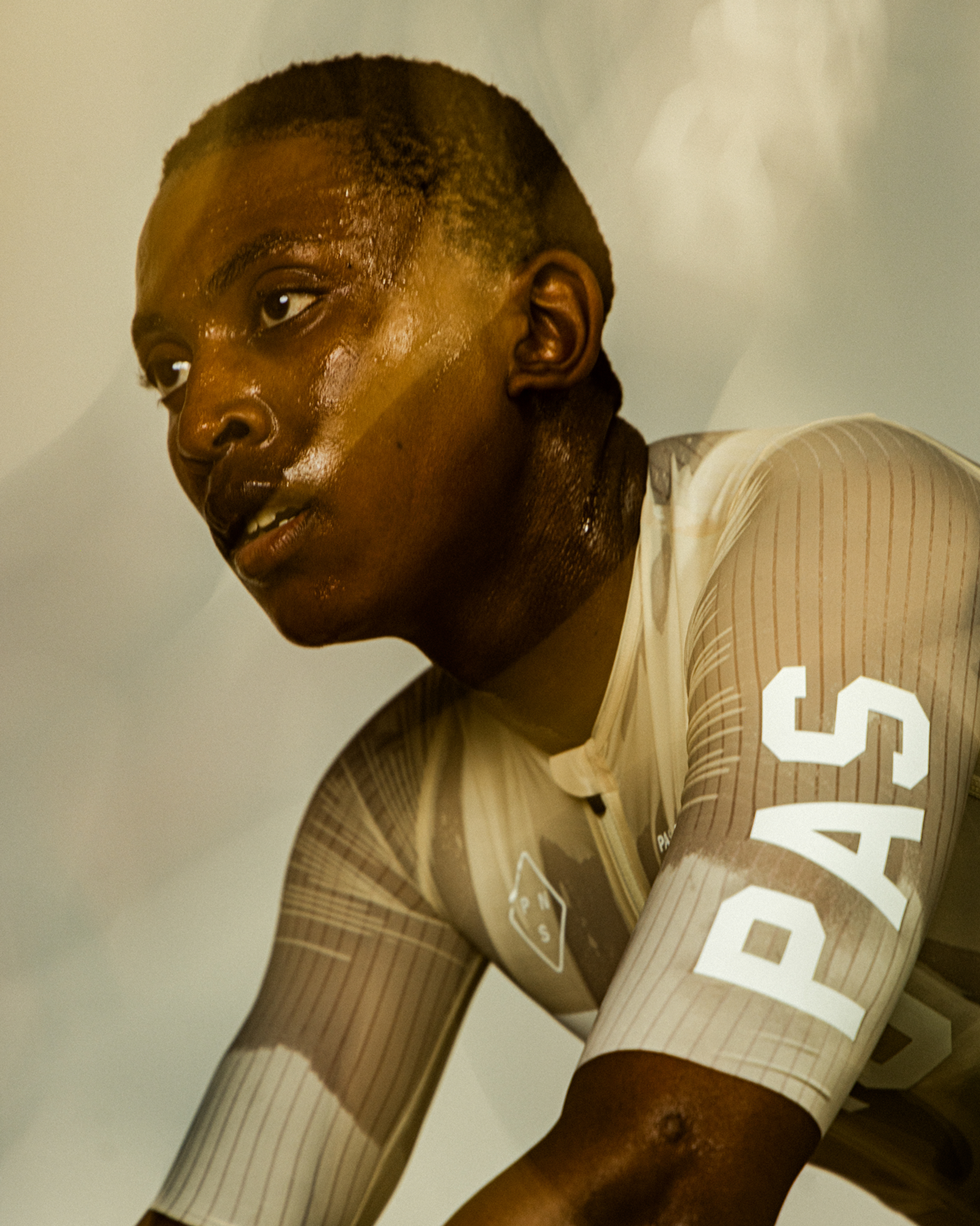 Model wearing beige ribbed jersey with white sleeve lettering and logo detailing