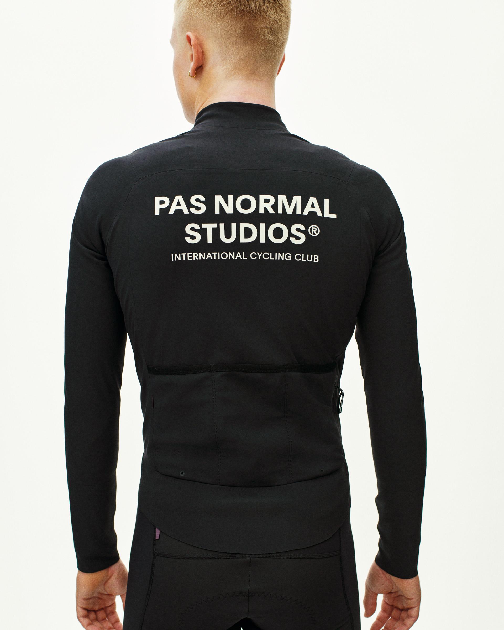 Black Mechanism Thermal cycling jacket, rear view on model with white logo and back pockets