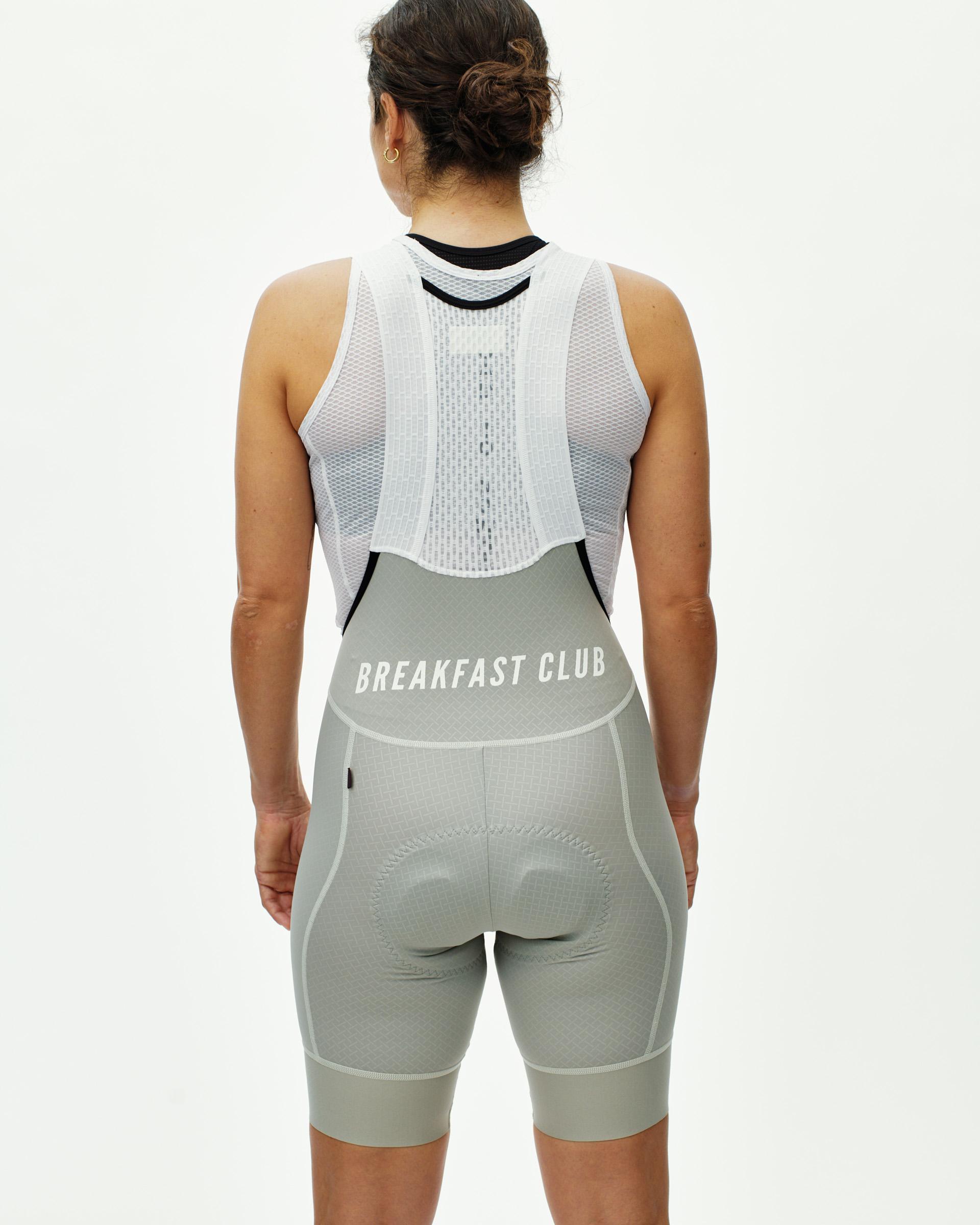 Light Grey Mechanism Breakfast Club women's cycling bibs, rear view on model with white bib straps and back print