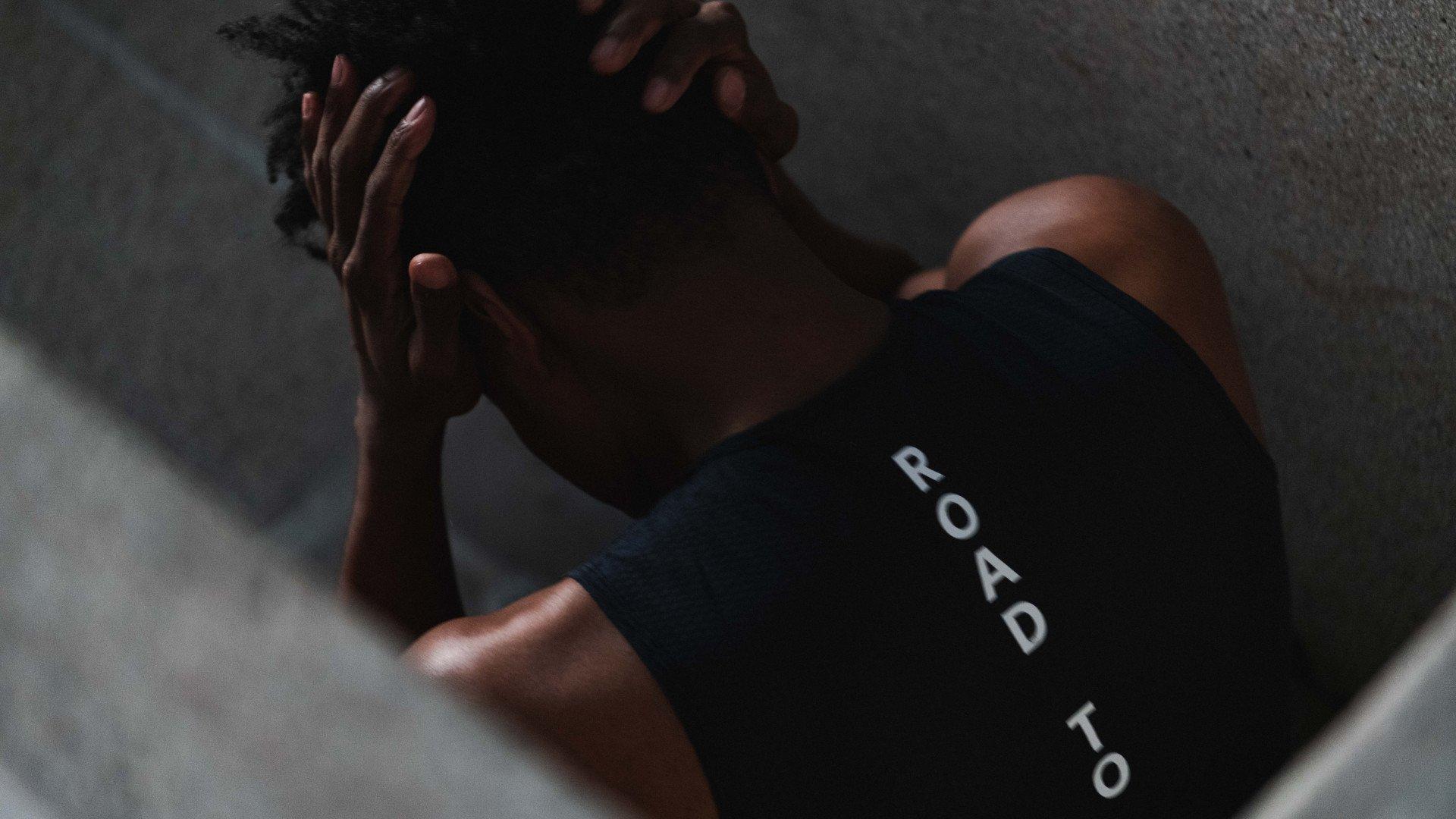 Model wearing black cycling shorts with white text lettering lying on concrete surface