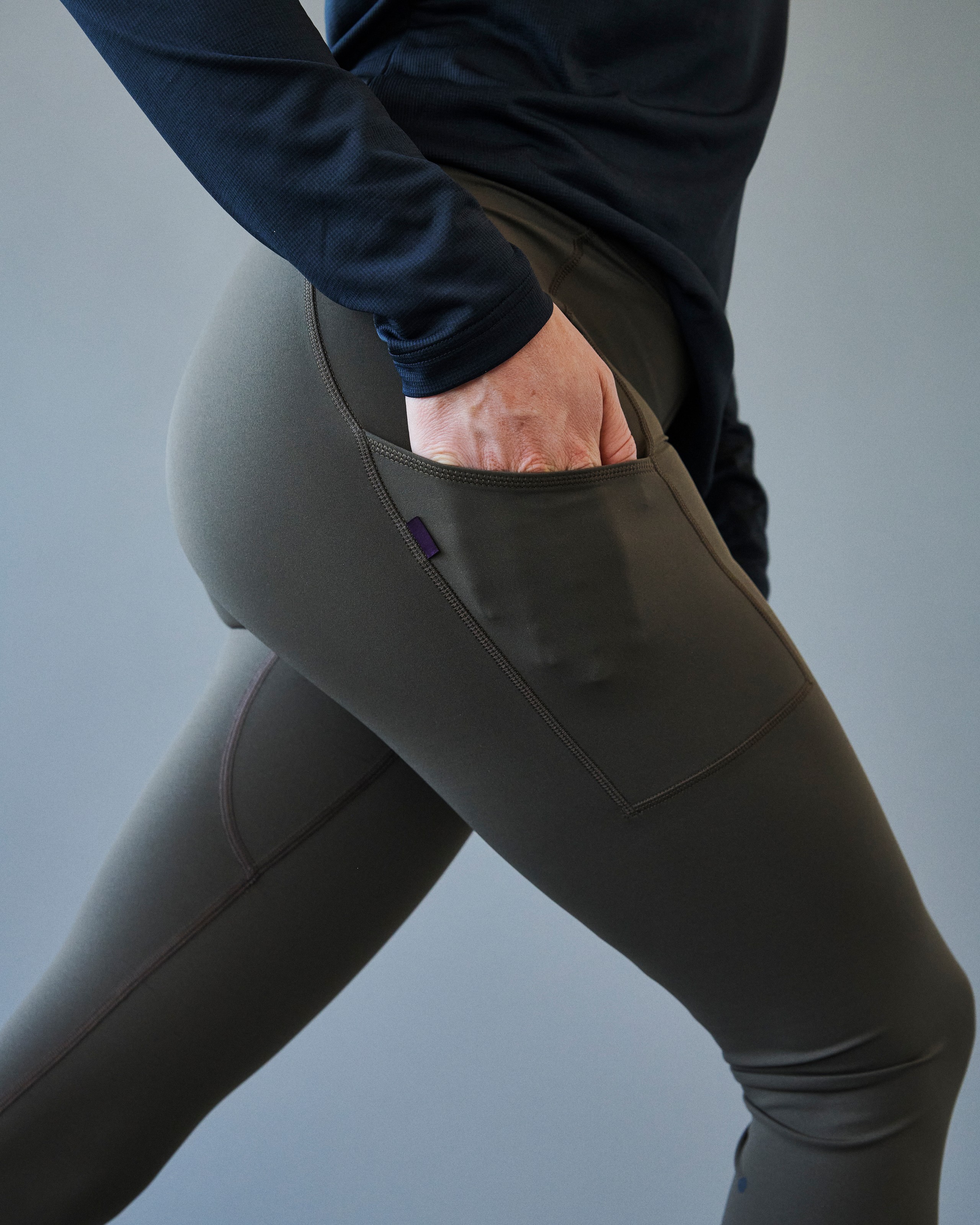 Brown Balance long tights on model showing side pocket with purple label detail