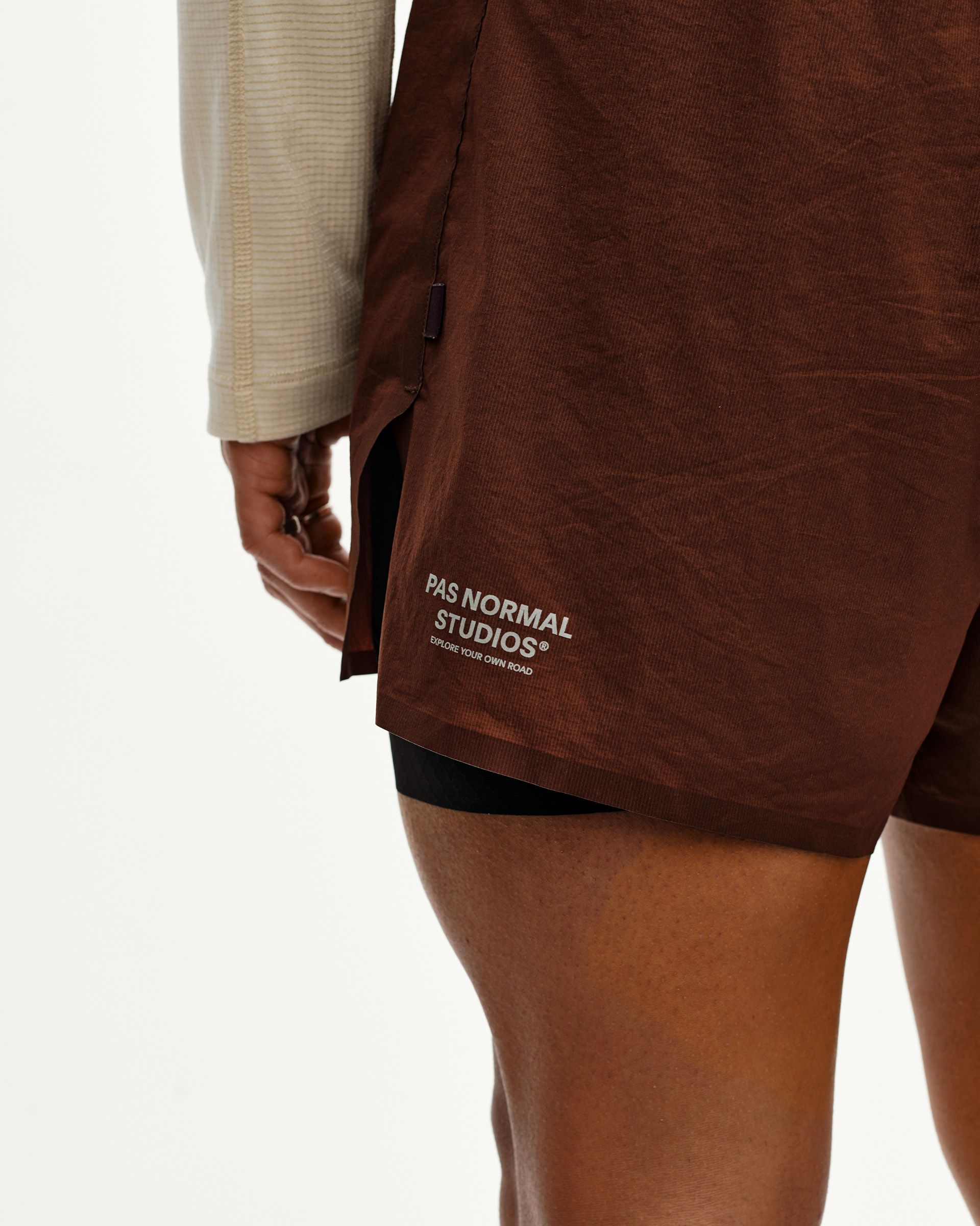 Maroon Brown Balance 2-in-1 shorts on model, side detail view with black inner liner and logo print