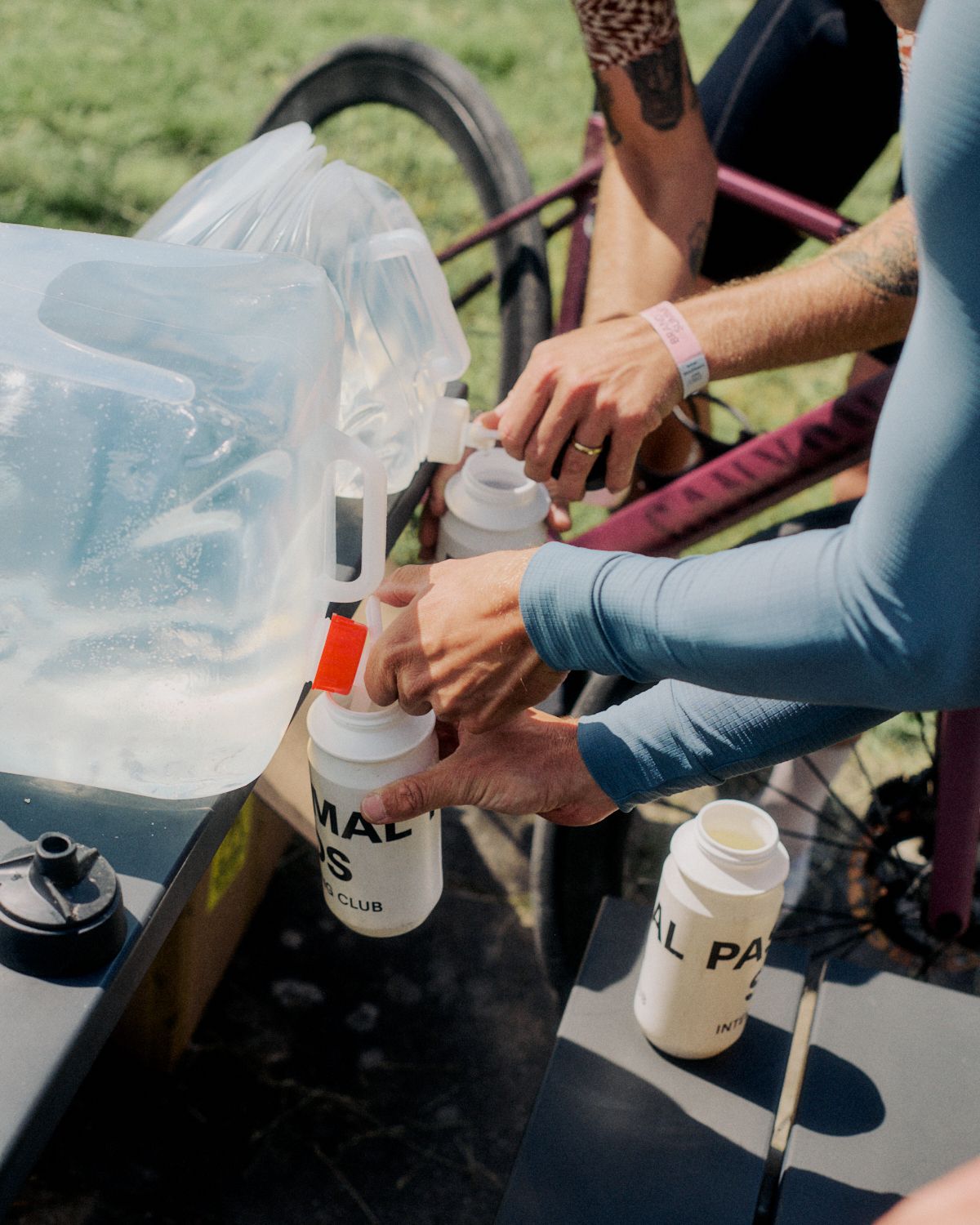 Cyclists refilling water bottles during Brand Summit 2024 outdoor event