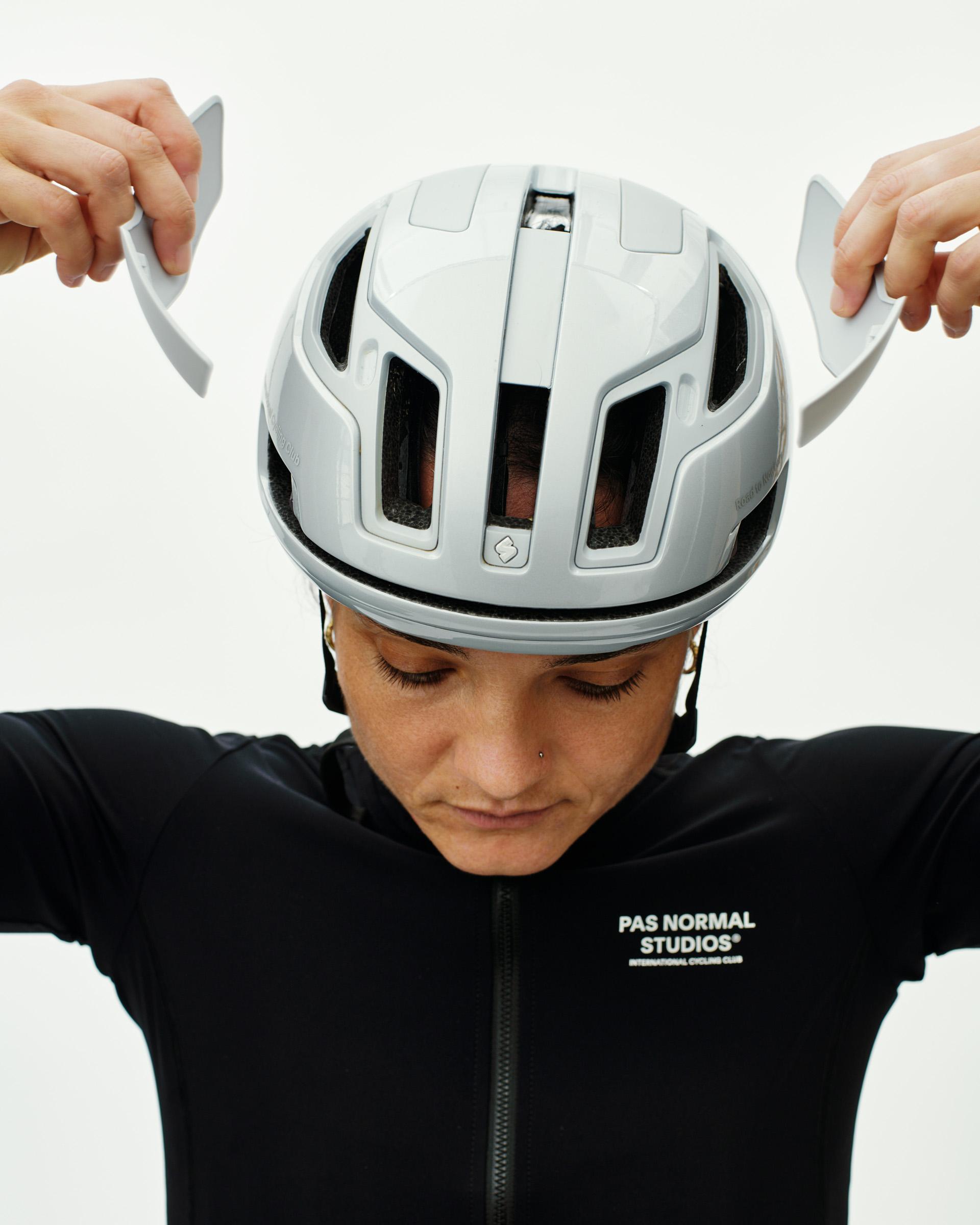Silver Sweet Protection Falconer Aero 2Vi MIPS cycling helmet on model adjusting fit with ventilated shell