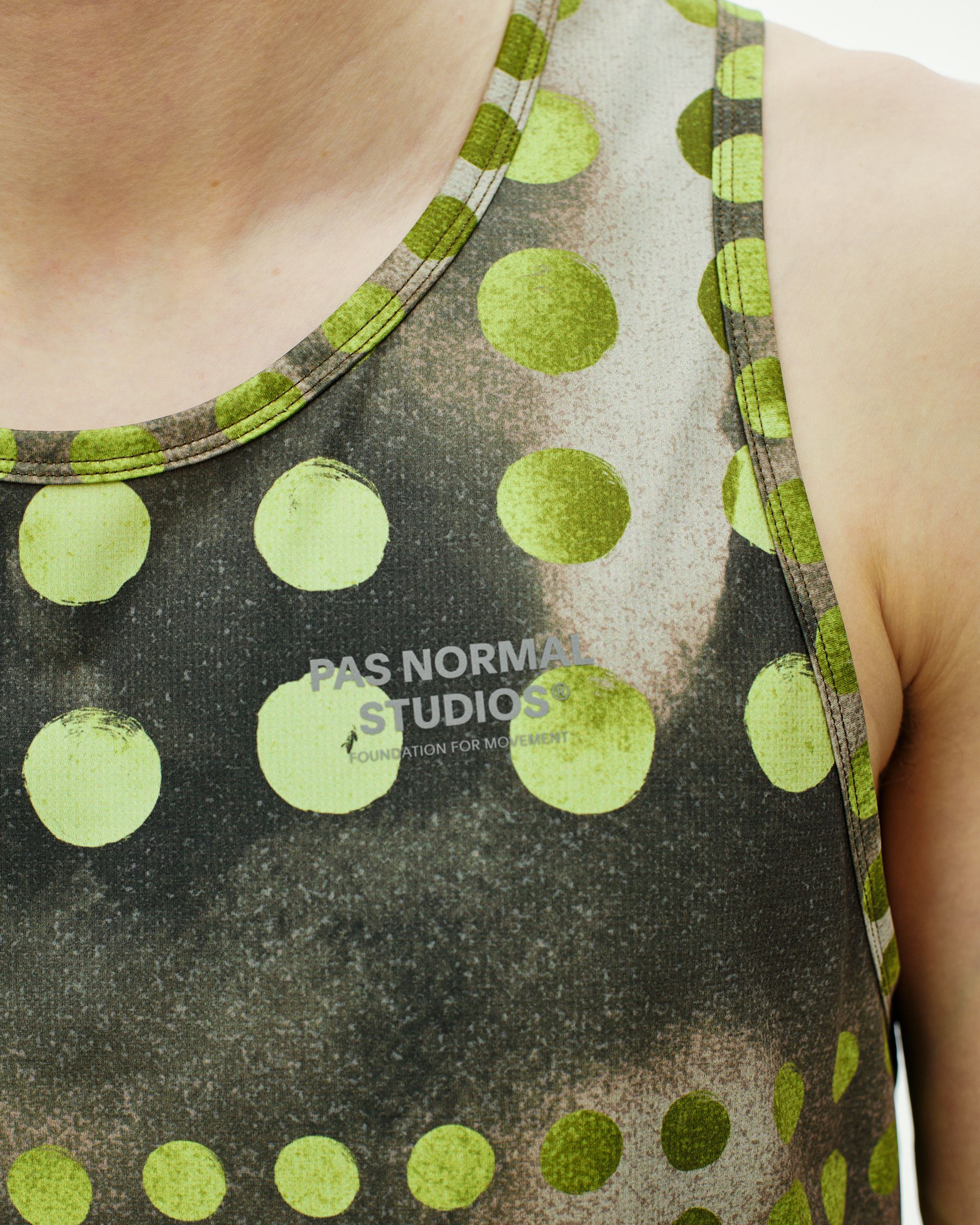 Green T.K.O. Balance singlet on model with polka dot print