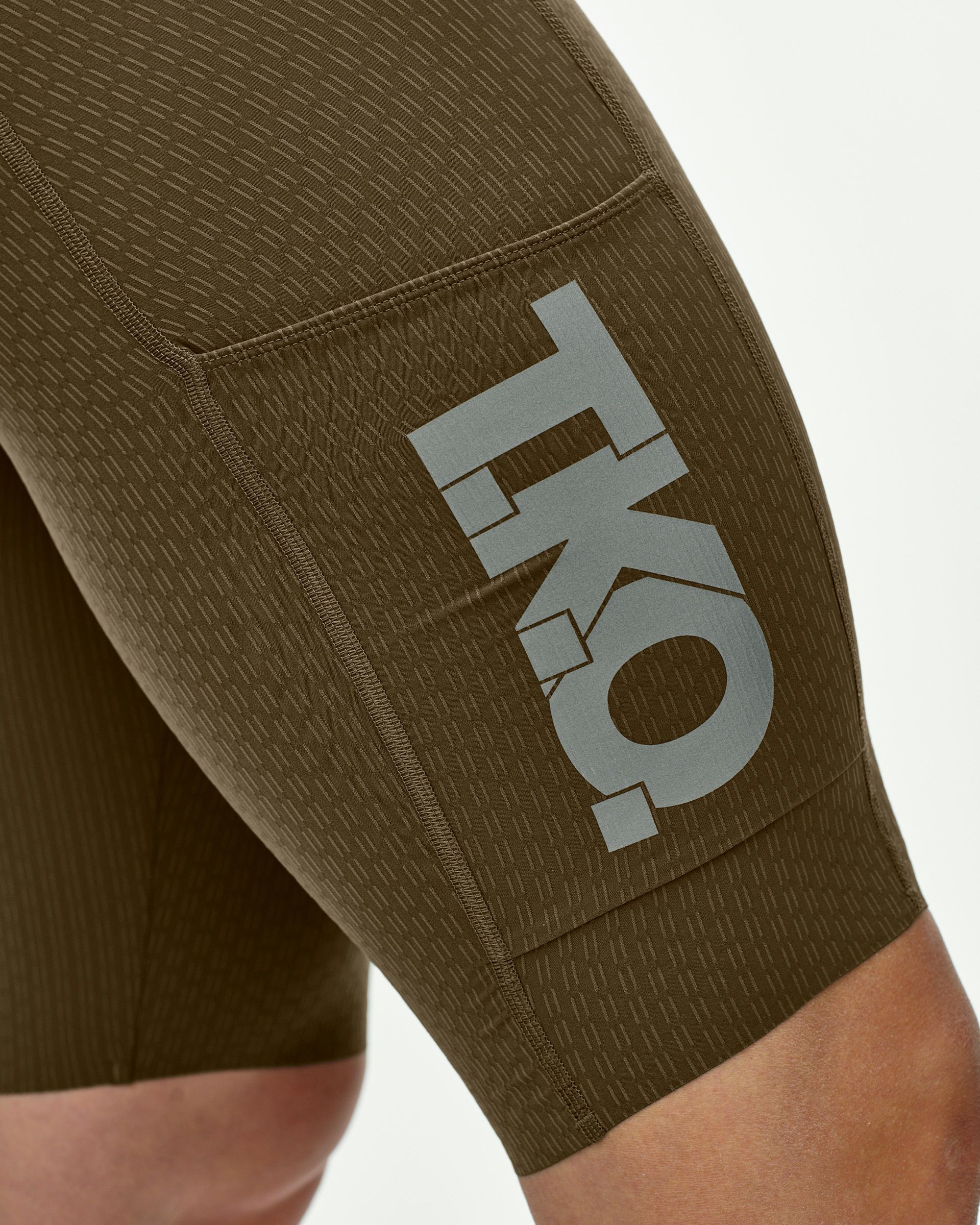 Dark Stone T.K.O. Essential Light Cargo bibs on model, side view with grey logo on thigh panel
