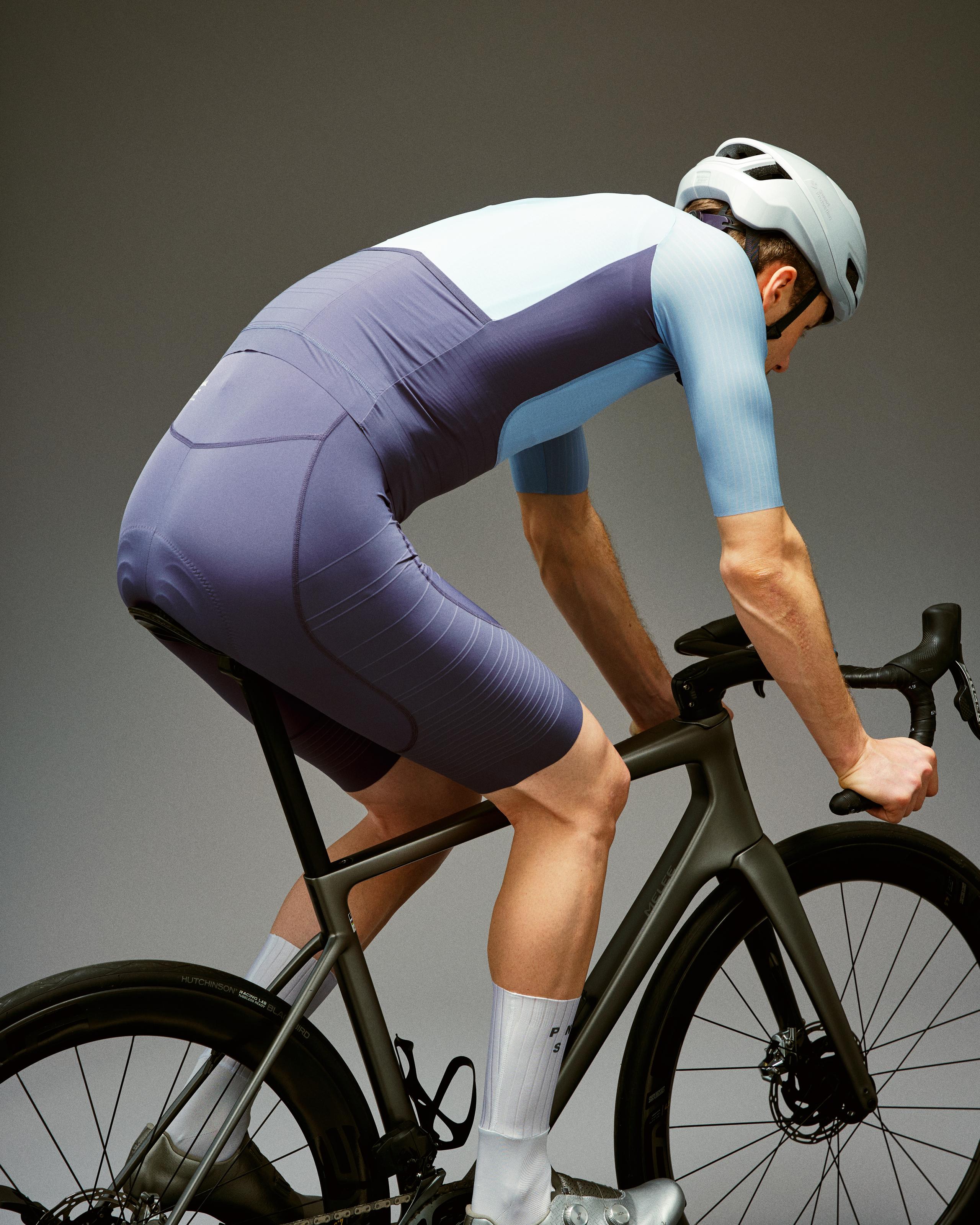Grey Mechanism Pro cycling jersey on model in aerodynamic position with pale blue sleeves