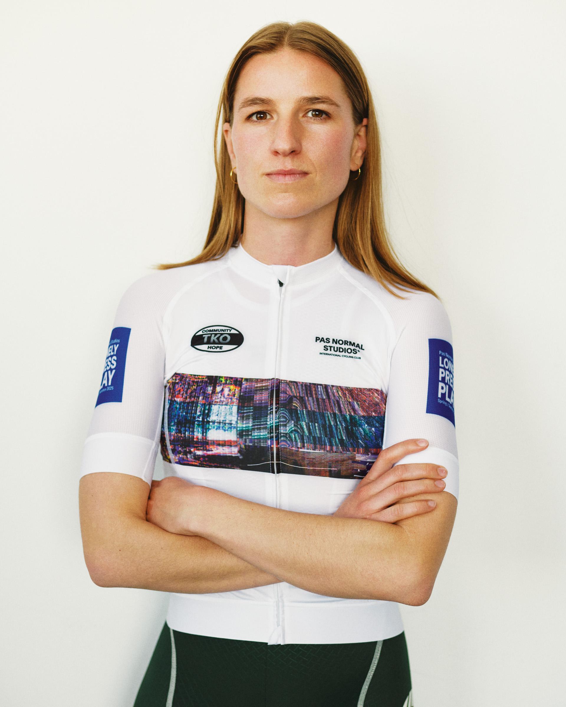 White T.K.O. Mechanism women's cycling jersey on model, front view with abstract glitch print panel and blue sleeve graphics