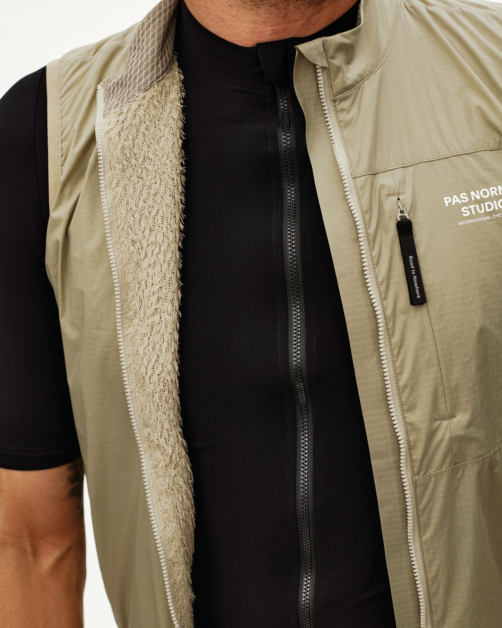 Grey Sage Essential cycling gilet, front detail on model, open zip showing knit inner lining and chest pocket