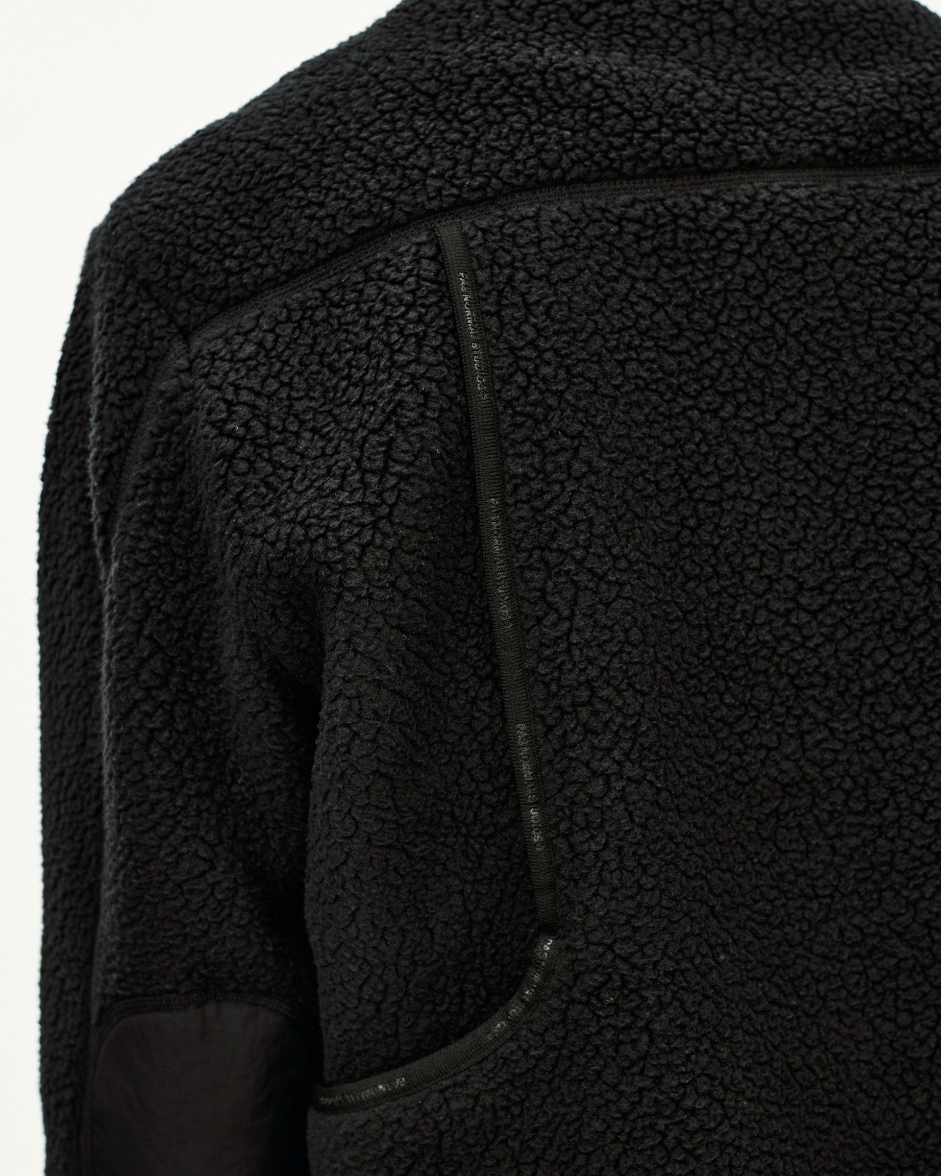 Black Off-Race Pile Fleece jacket, detail view of shoulder and side zip pocket on sherpa texture