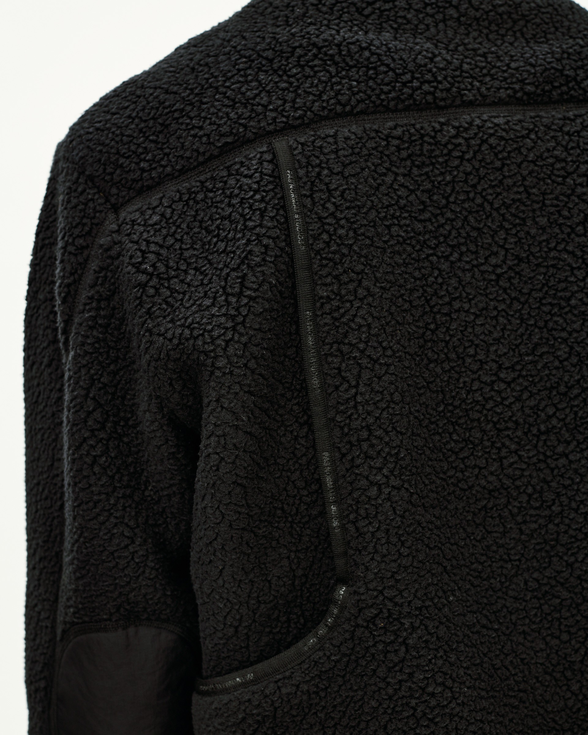 Black Off-Race Pile Fleece jacket, detail view of shoulder and side zip pocket on sherpa texture