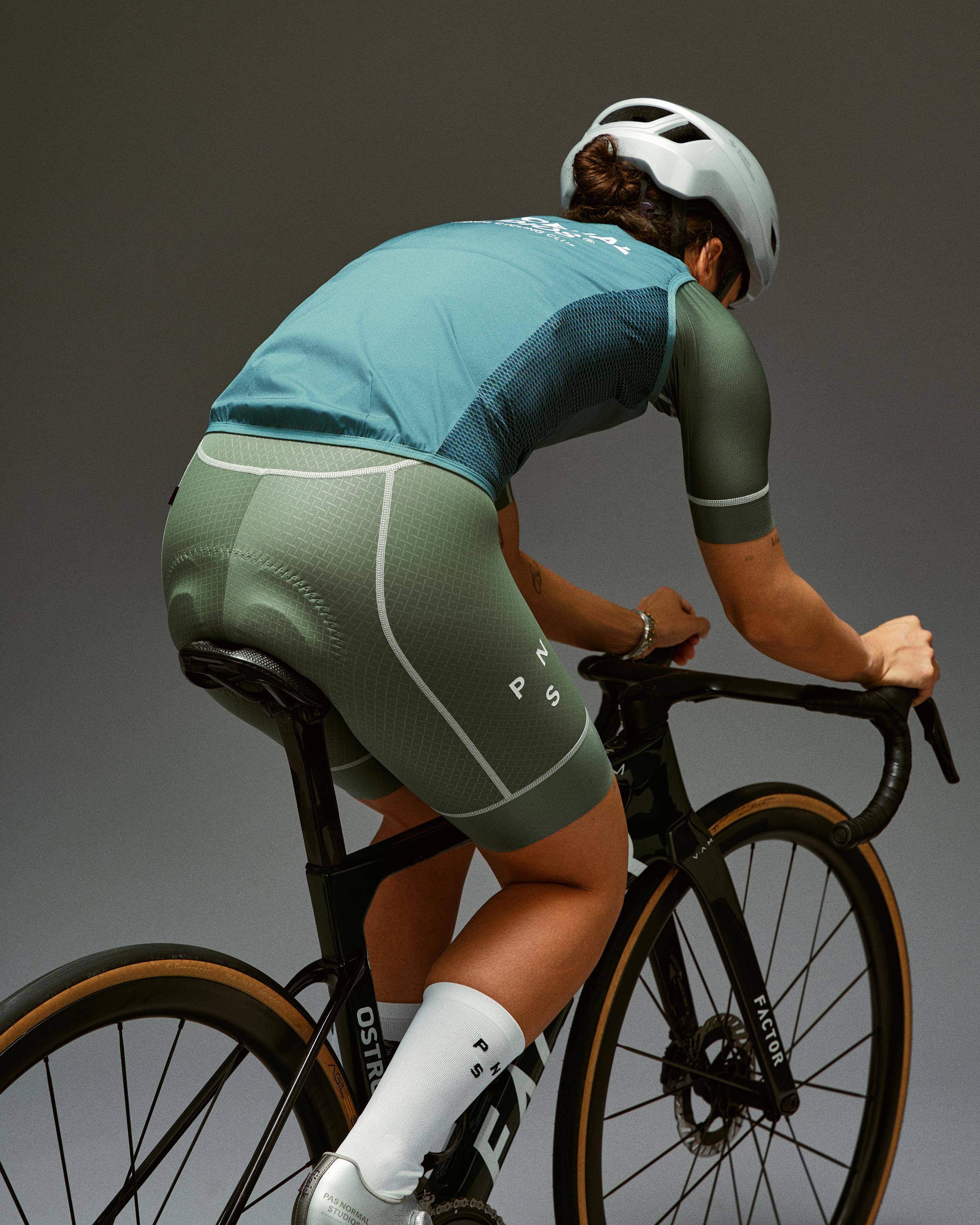 Grey Mechanism Stow Away gilet on cyclist in aerodynamic position with mesh back panel