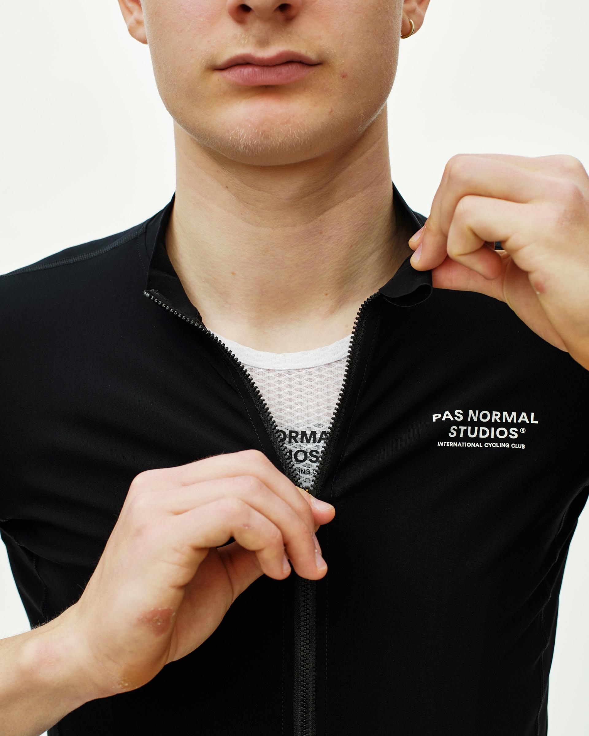 Black Essential cycling jersey on model with full zip and white chest logo