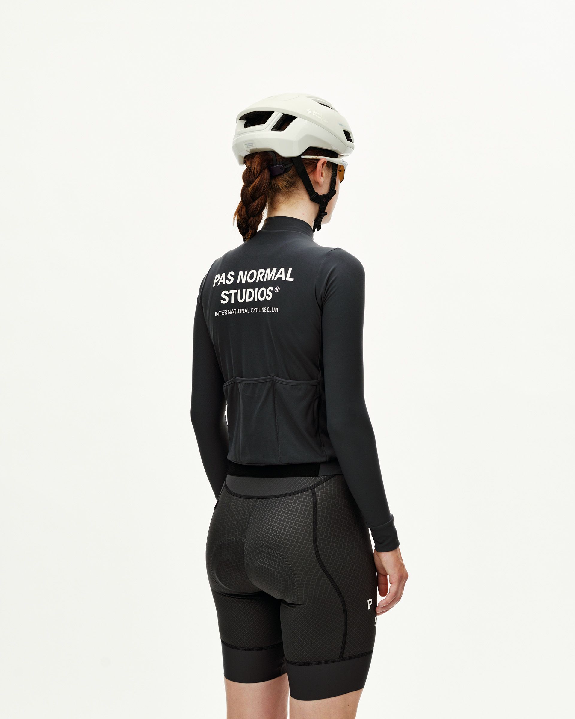 Dark Navy Mechanism women's long sleeve cycling jersey on model, rear view with white back print and three rear pockets
