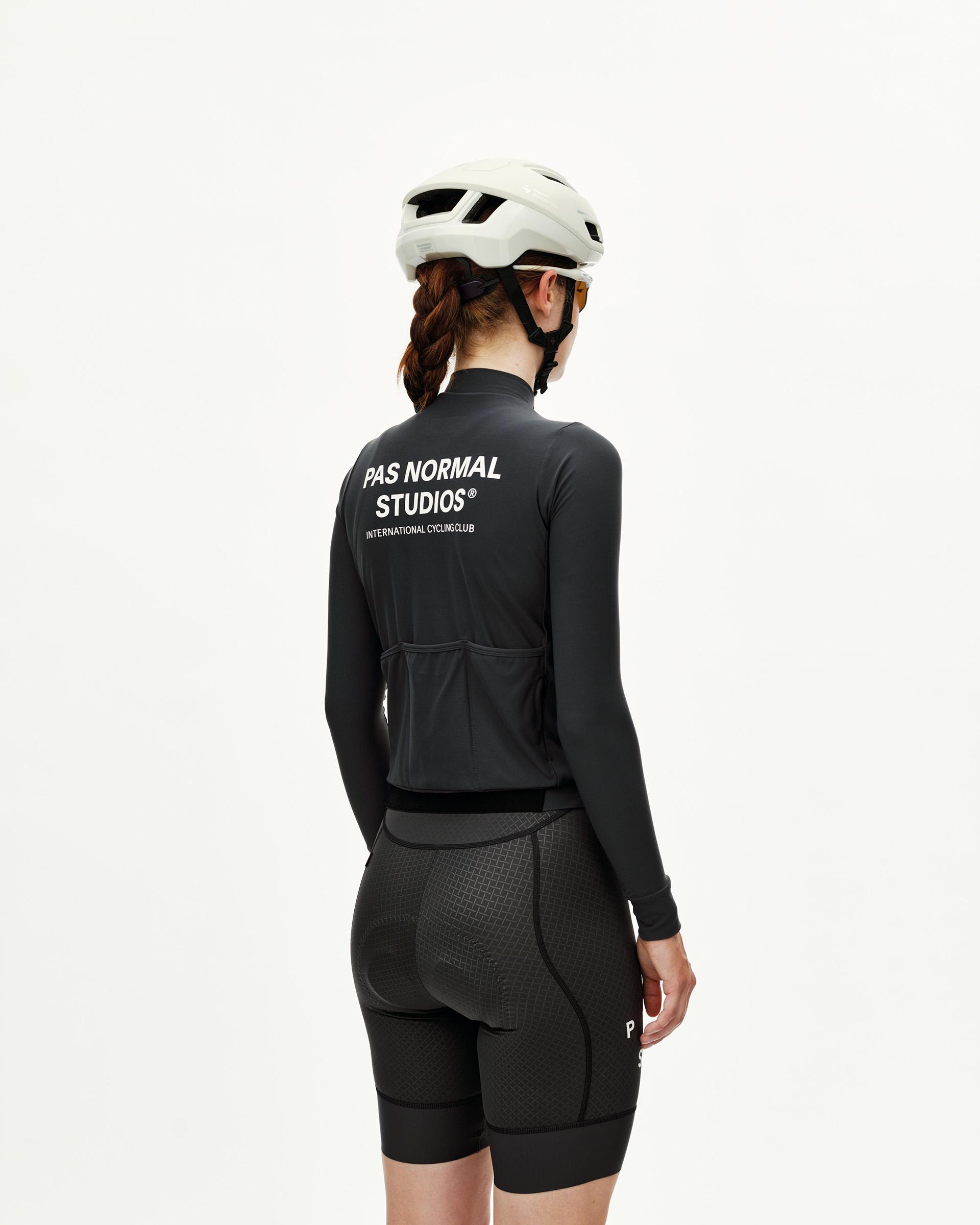 Dark Navy Mechanism women's long sleeve cycling jersey on model, rear view with white back print and three rear pockets