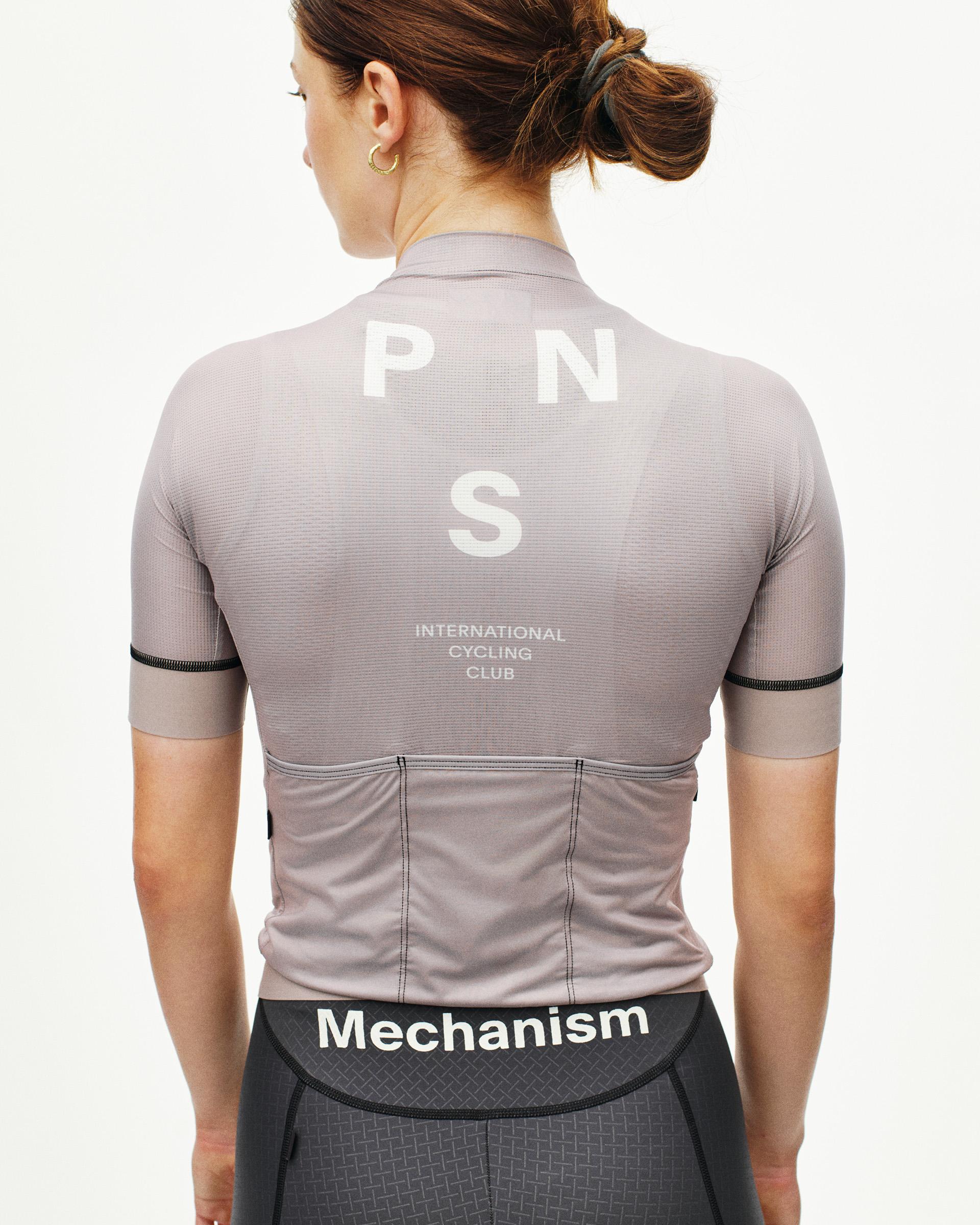 Grey Mechanism cycling jersey on model, rear view with white PNS logo and black sleeve trim