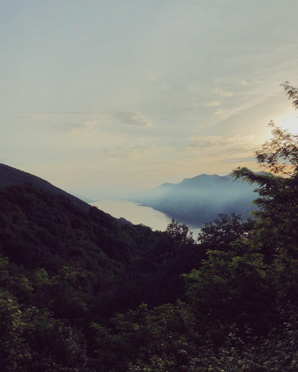 Mountain landscape view with lake and misty peaks at dawn