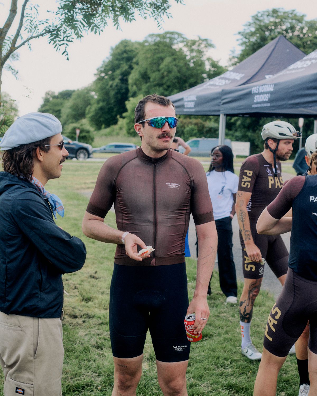 Model wearing brown cycling jersey with sunglasses at outdoor cycling event