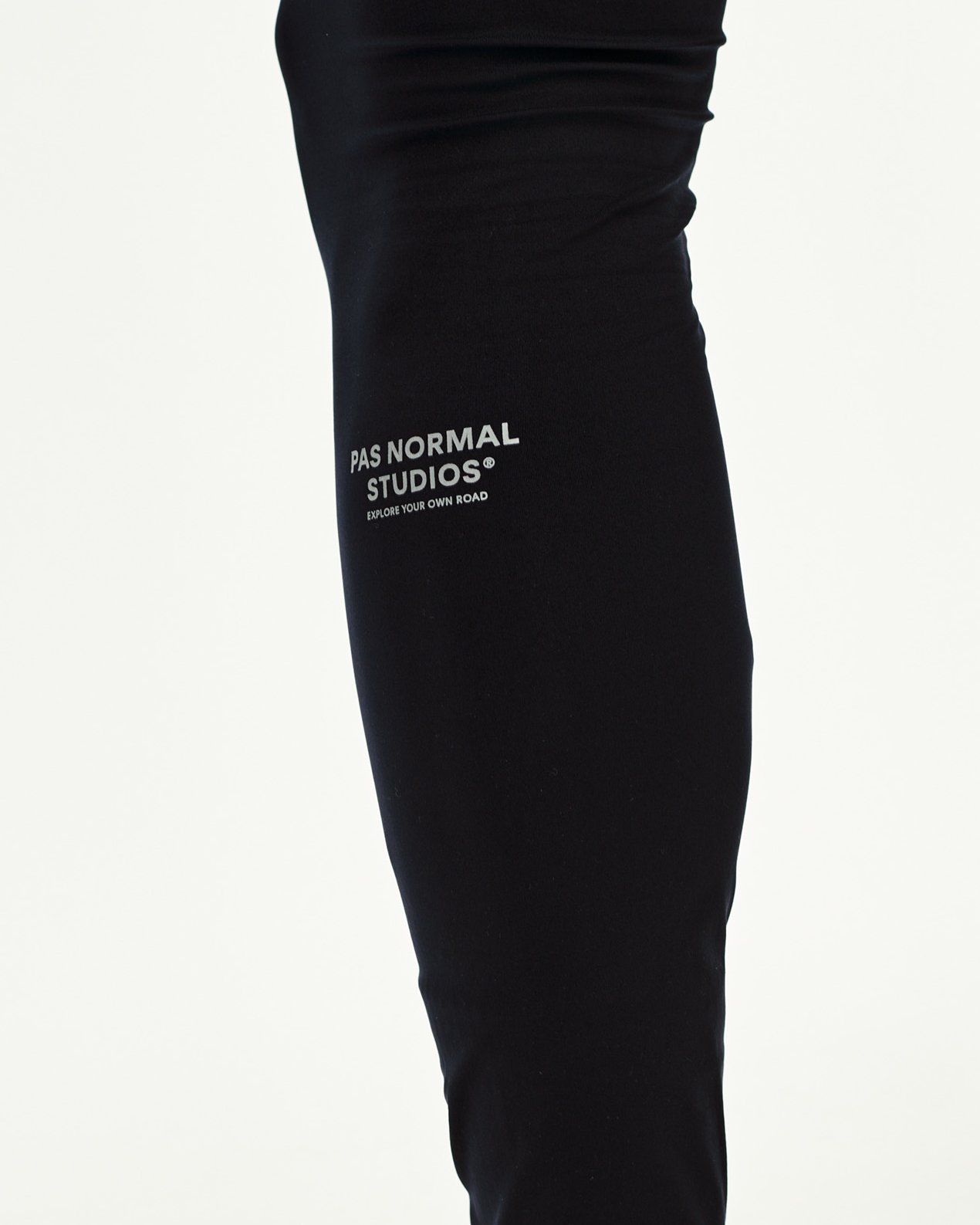 Black Balance long cycling tights, side detail on model with grey logo print
