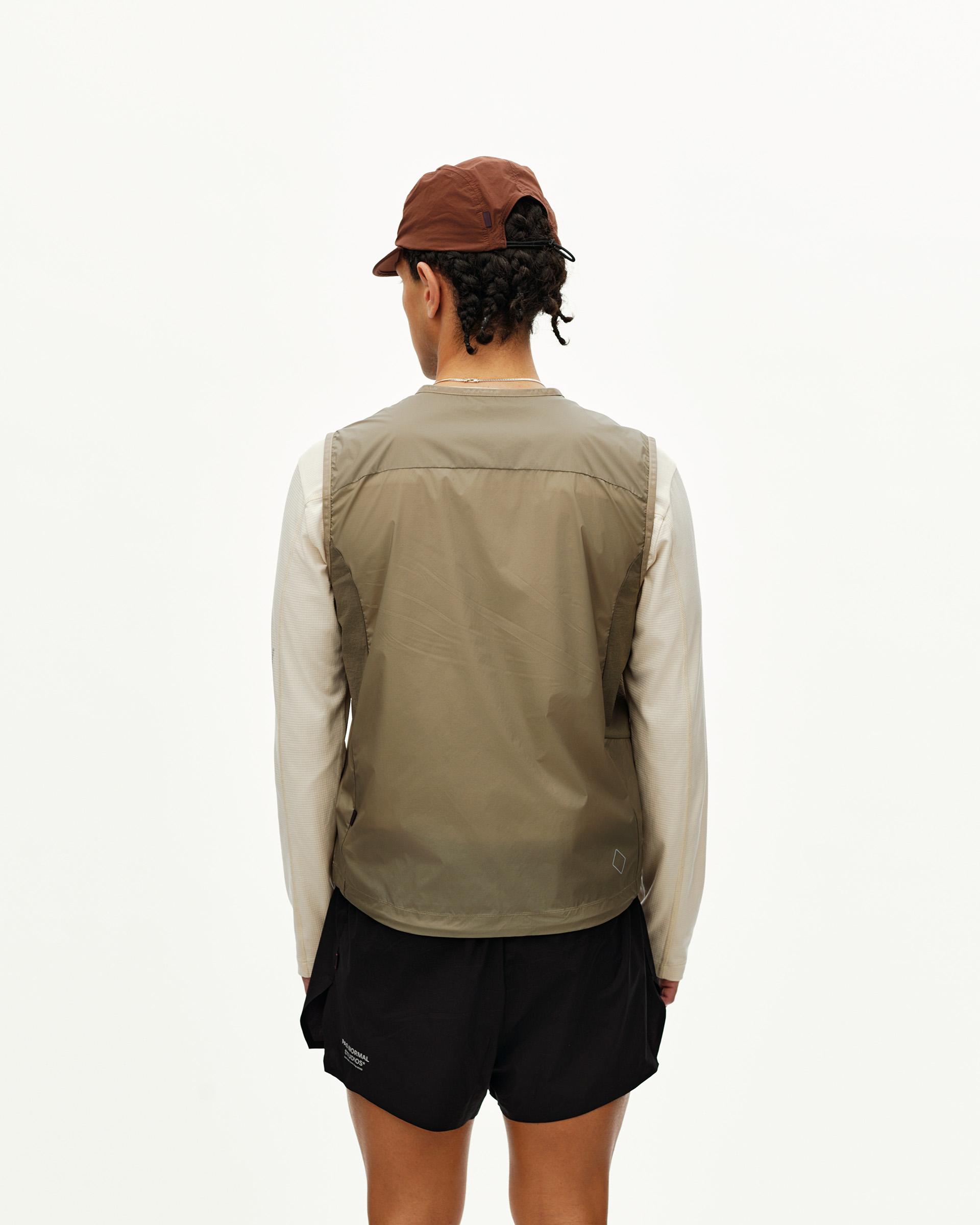 Dusty Earth khaki Balance Windproof vest on model, rear view with contrast side panels