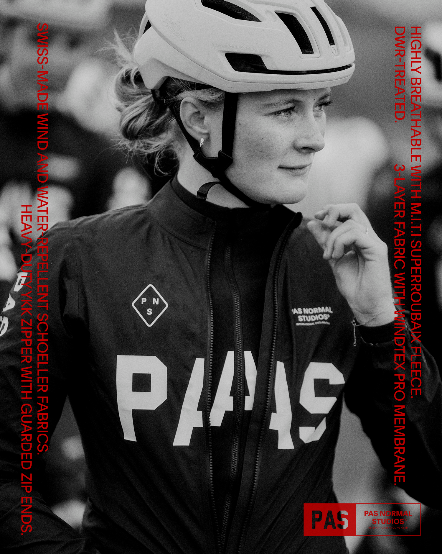 Model wearing black cycling jacket with white logo branding and white helmet in profile shot