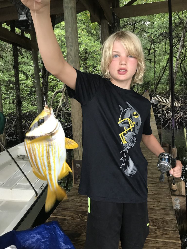 Young guest catching fish off the dock