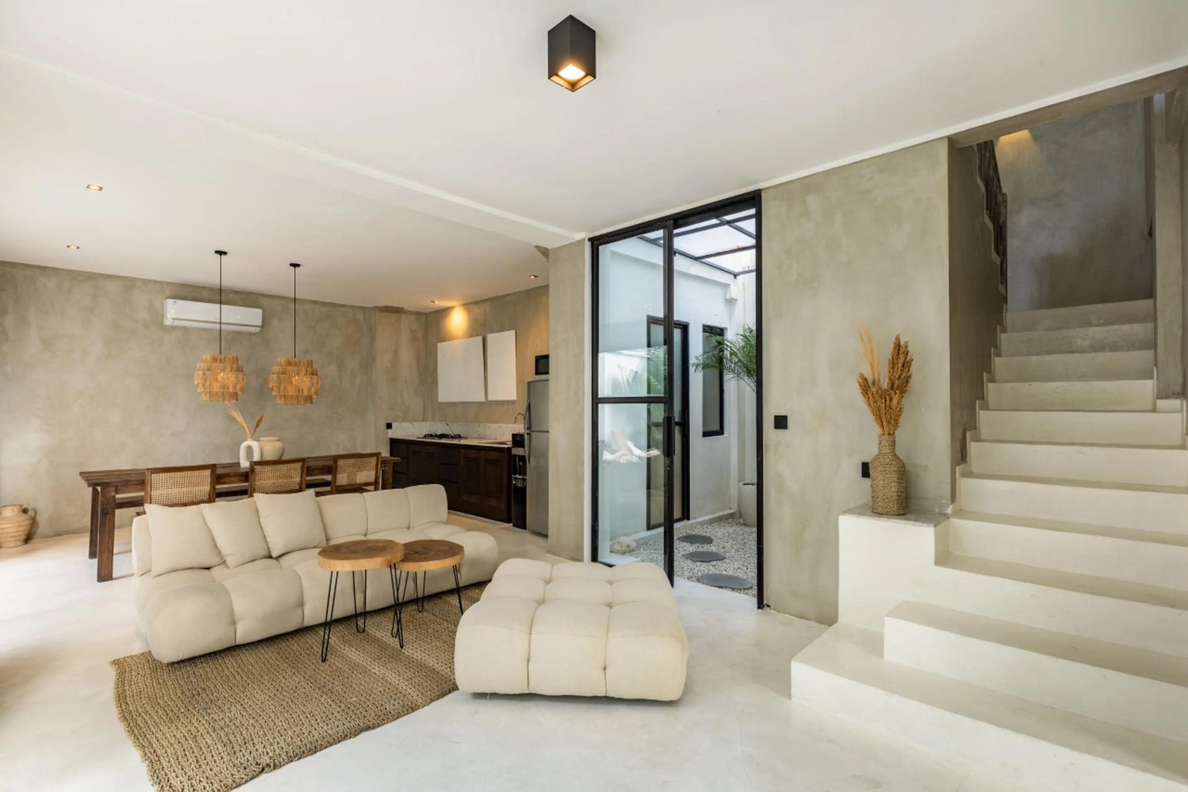 Open-plan villa living room with kitchen and courtyard pool beyond — Canggu, Bali — OriVista