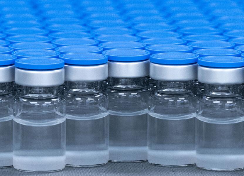 Group of glass vaccine vials with blue caps