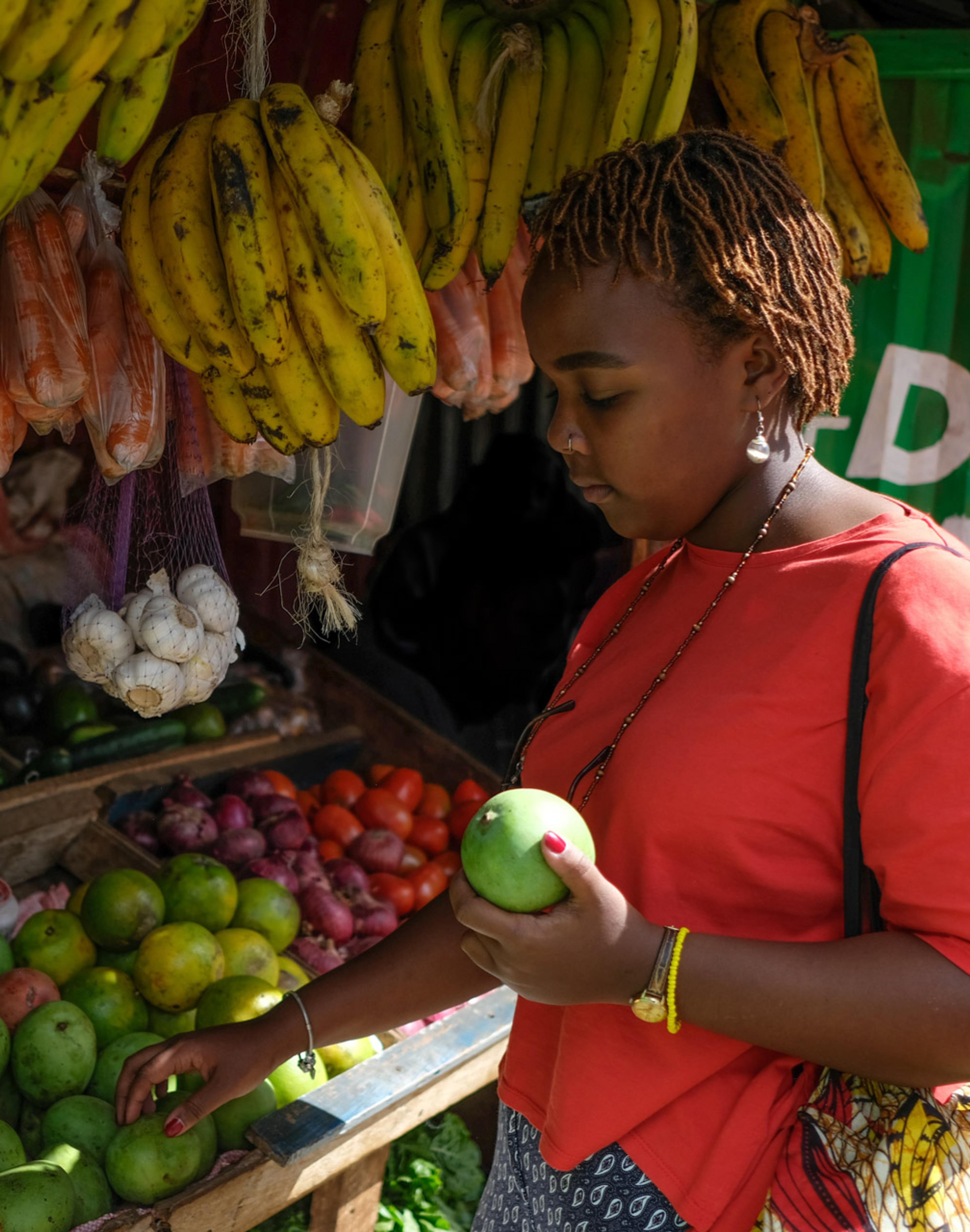Woman picking fruit from market stall