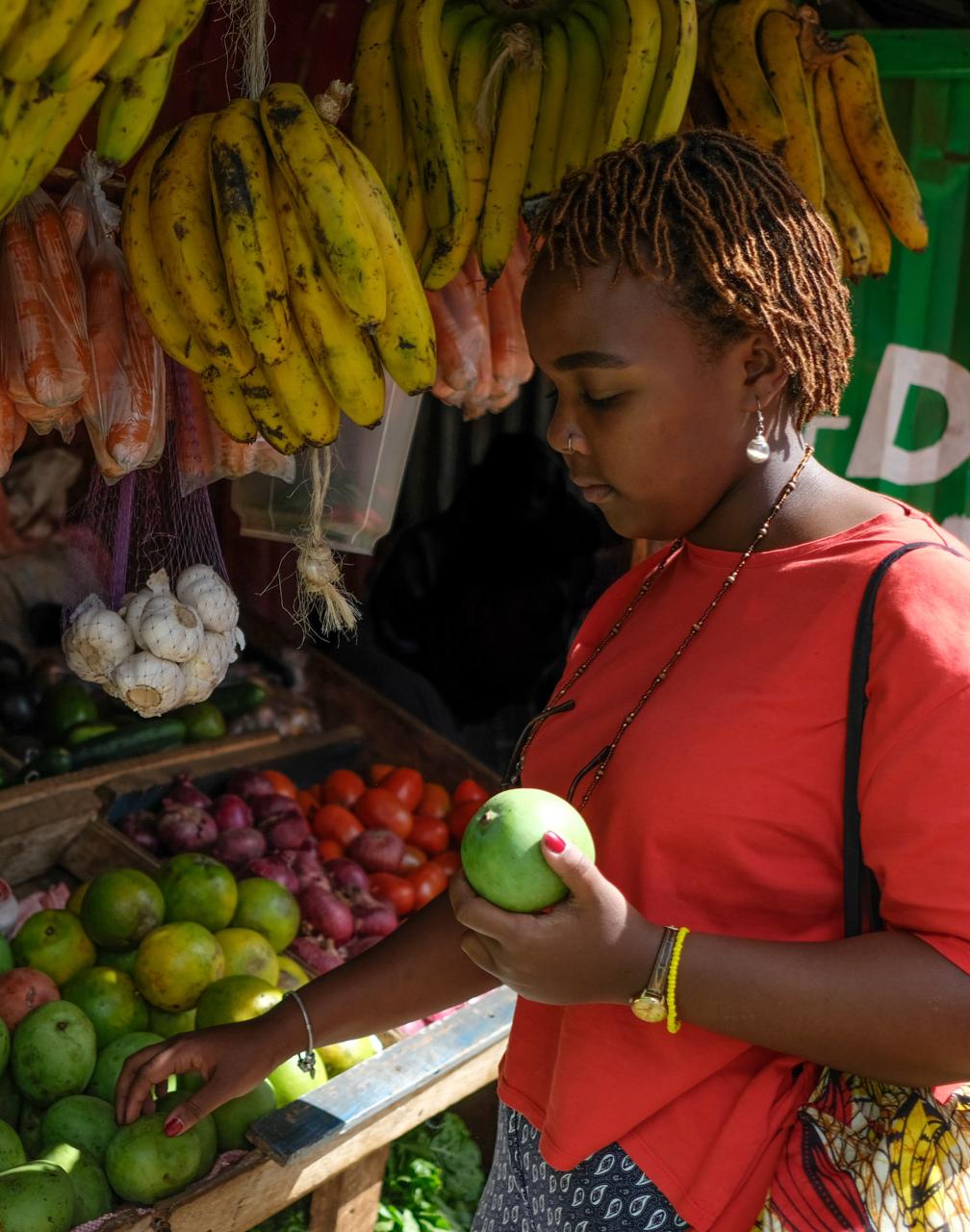 Woman picking fruit from market stall