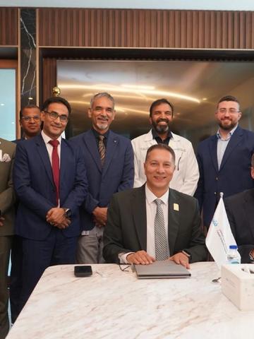 Leadership from Verita Healthcare Group and Fakeeh University Hospital gathered in formal attire during a partnership meeting in a wood- and marble-paneled boardroom.
