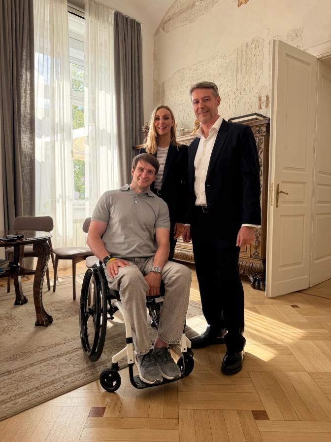 Epidural Stimulation Patient in wheelchair accompanied by a standing male and female from Verita Neuro Senior Management in Lviv City Hall