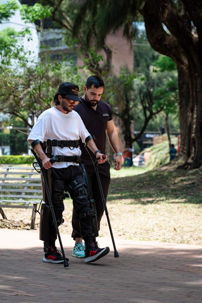 A paraplegic patient uses ReWalk Personal Robotic Exoskeleton to walk in the park